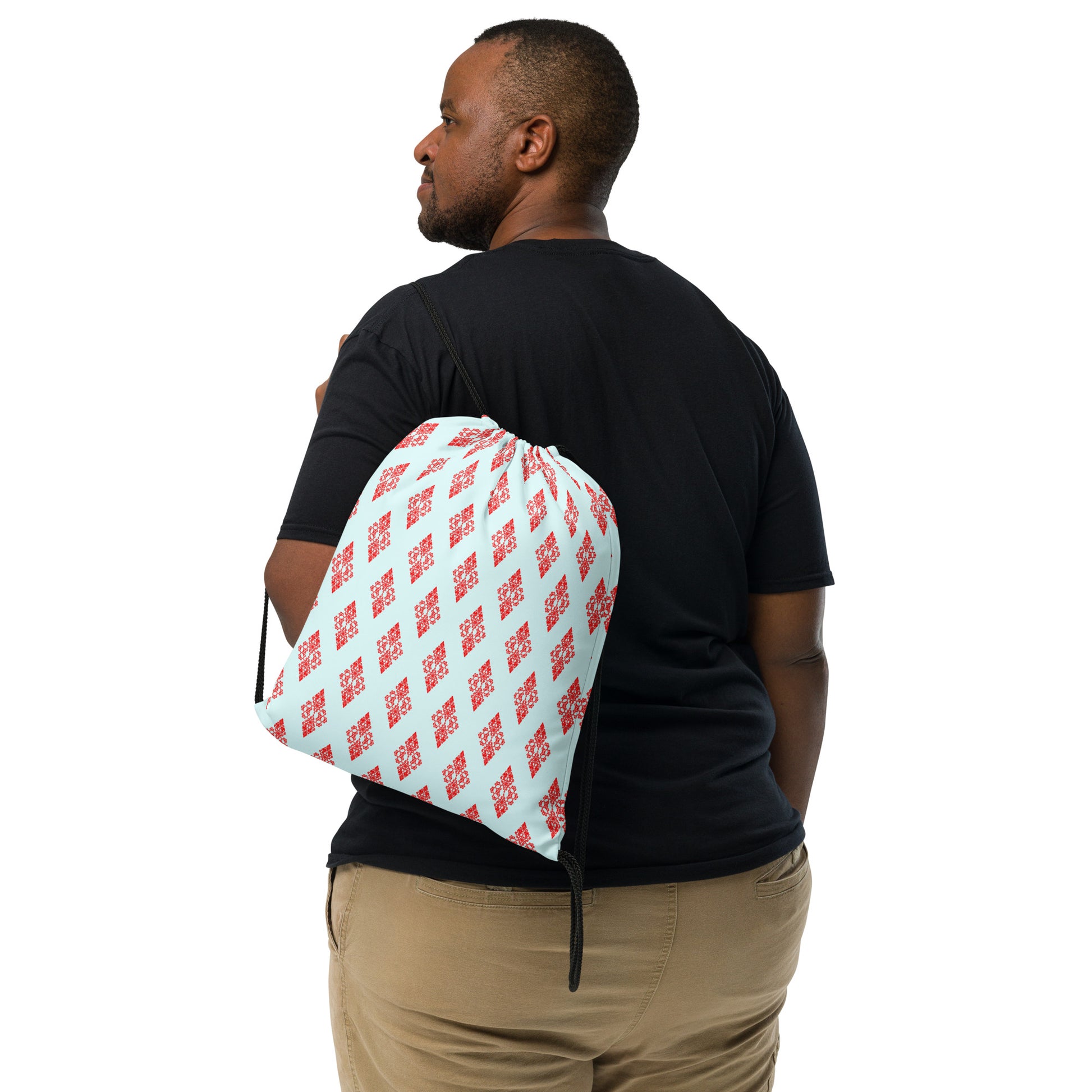 Back shot of the drawstring bag with the 'Digon' sky blue and red fractal geometric pattern slung over a man's shoulder.