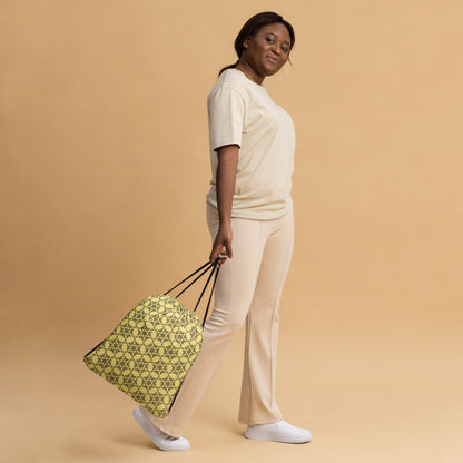Woman slinging the drawstring bag with the 'Hexagon' yellow and black fractal geometric pattern.