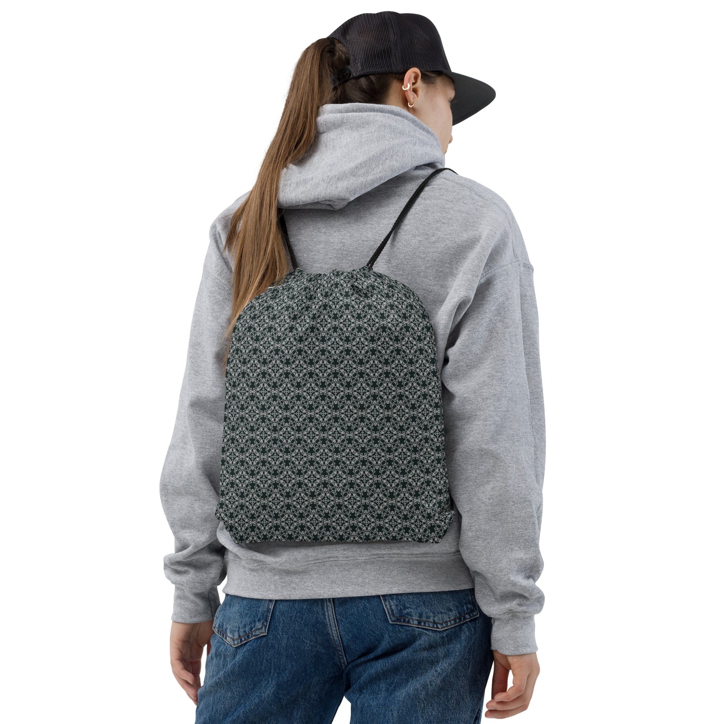 Back shot of a young woman wearing the drawstring bag with the 'Quadragon' charcoal and white fractal geometric pattern.