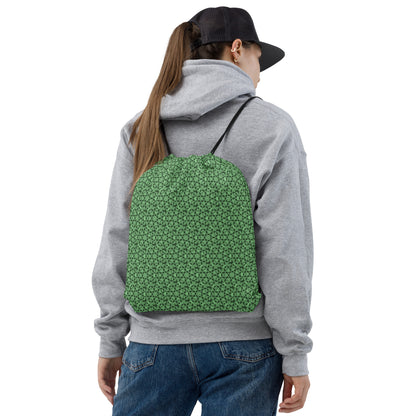 Back shot of a young woman wearing the drawstring bag with the 'Heptagon' green fractal geometric pattern.