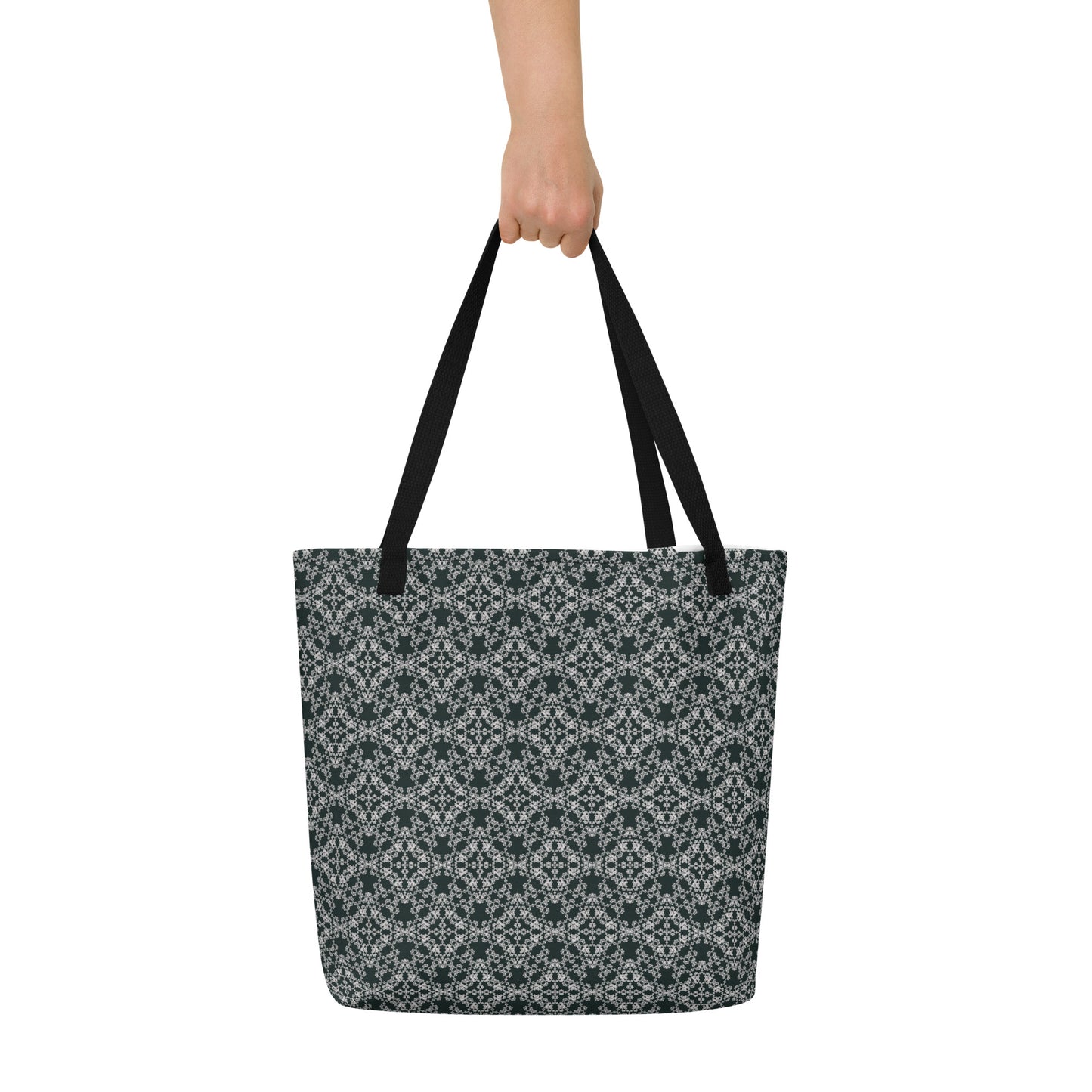 Hand holding the large tote bag with the 'Quadragon' charcoal and white fractal geometric pattern.