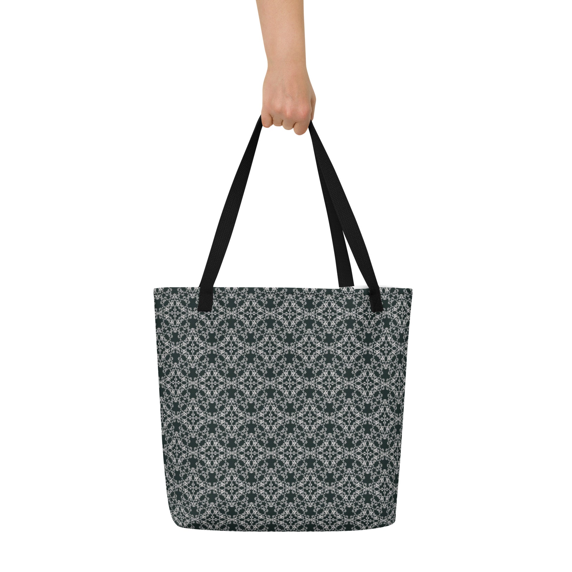 Hand holding the large tote bag with the 'Quadragon' charcoal and white fractal geometric pattern.
