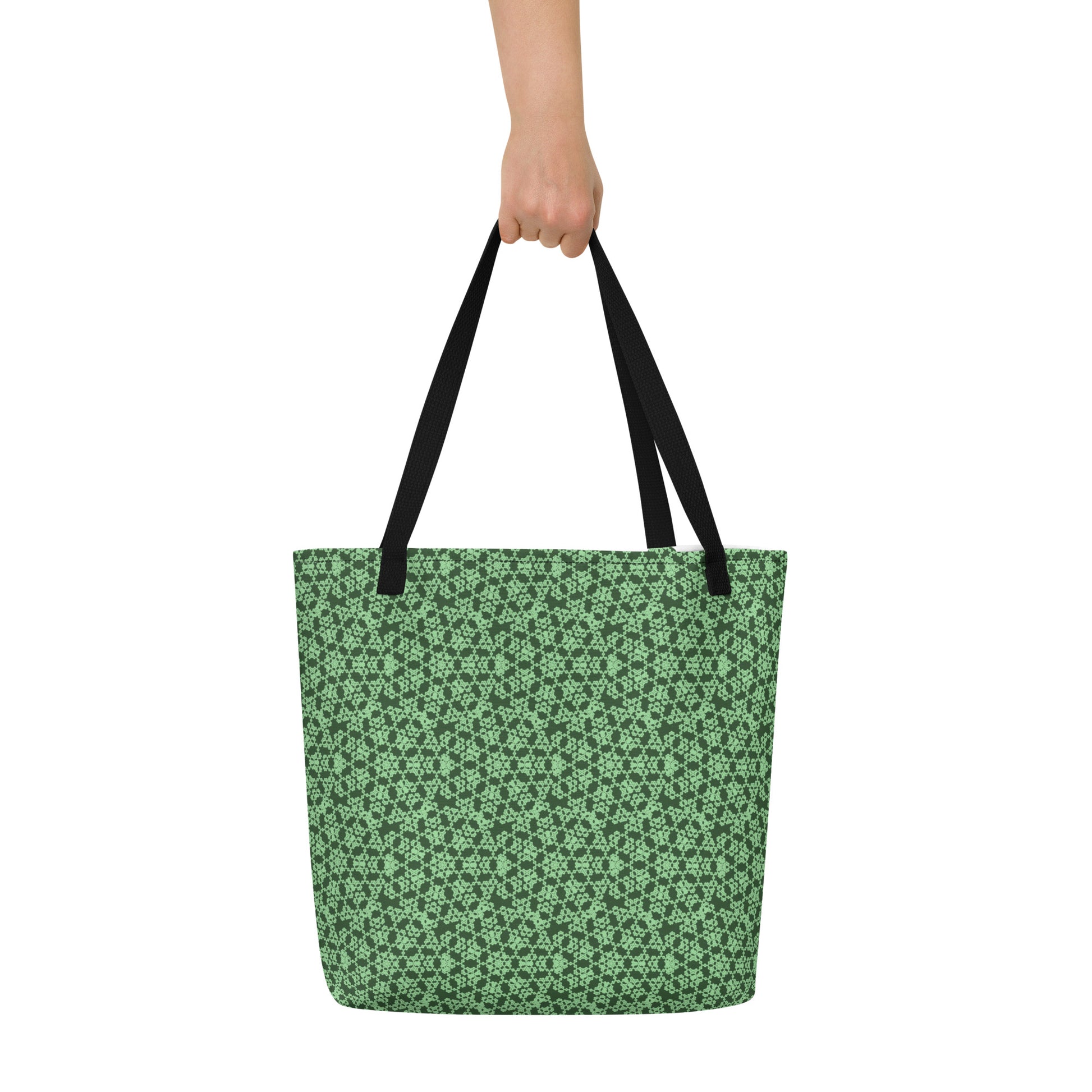 Hand holding the large tote bag with the 'Heptagon' green fractal geometric pattern.
