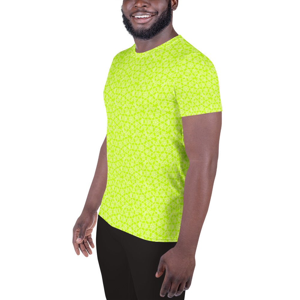 Left front shot of a model wearing the men's athletic t-shirt with the 'Heptagon' yellow-green fractal geometric pattern.