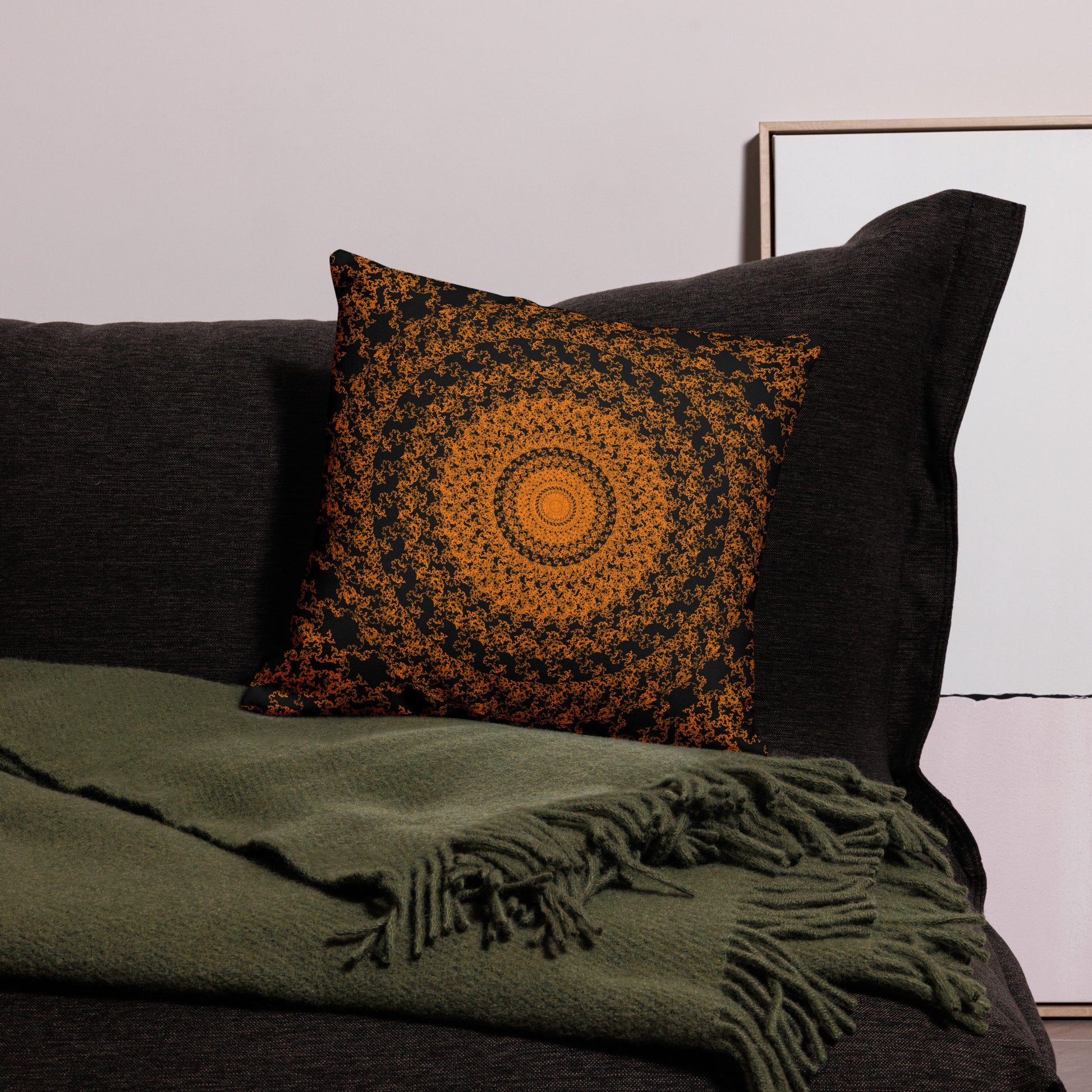 18″×18″ premium throw pillow with the 'The Sun' orange and black geometric design on a couch.
