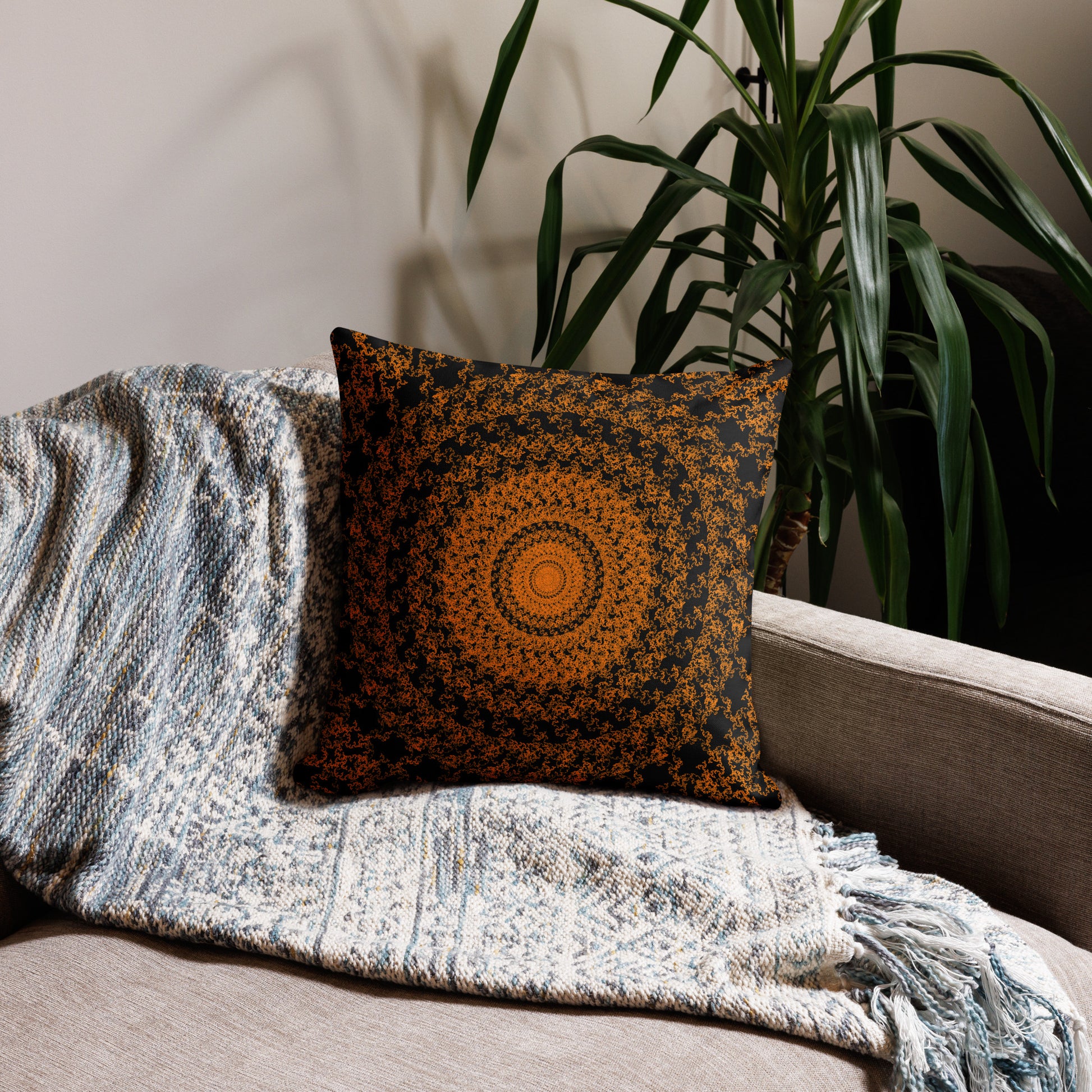 18″×18″ premium throw pillow with the 'The Sun' orange and black geometric design on a couch.