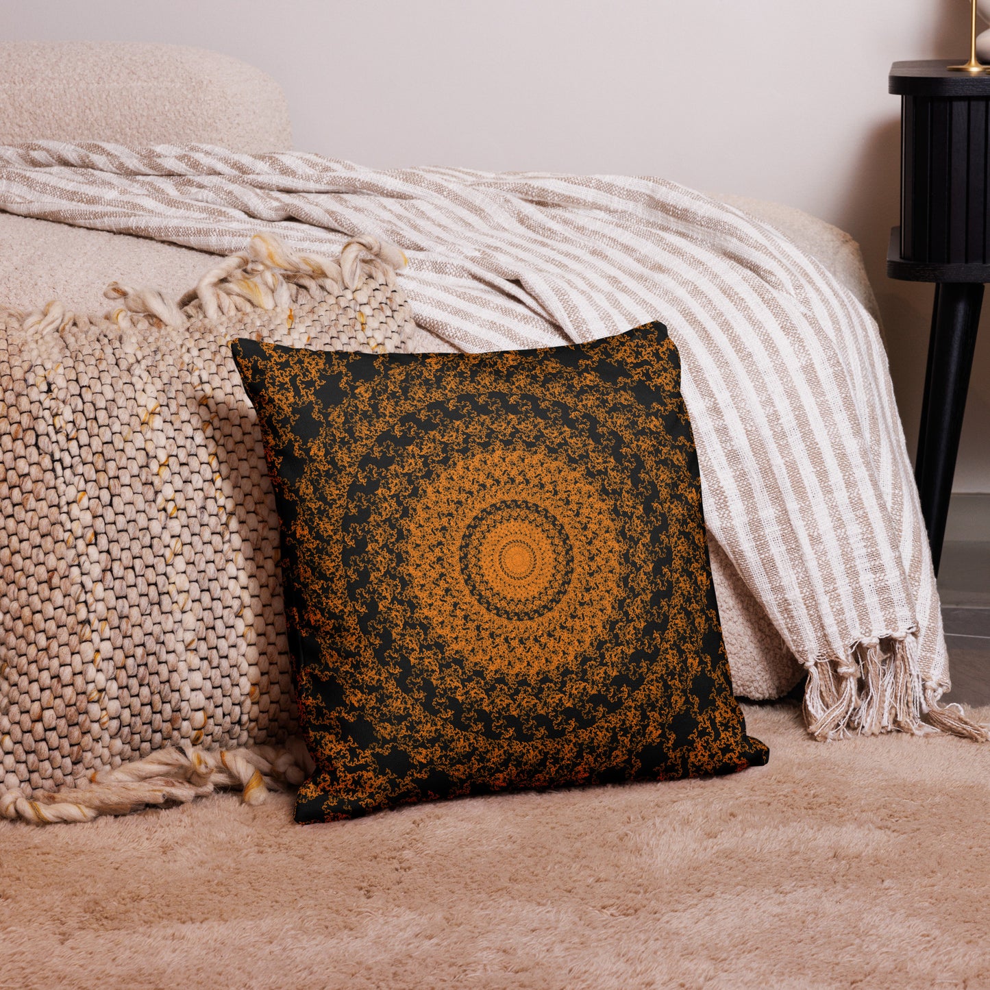 18″×18″ premium throw pillow with the 'The Sun' orange and black geometric design on a couch.