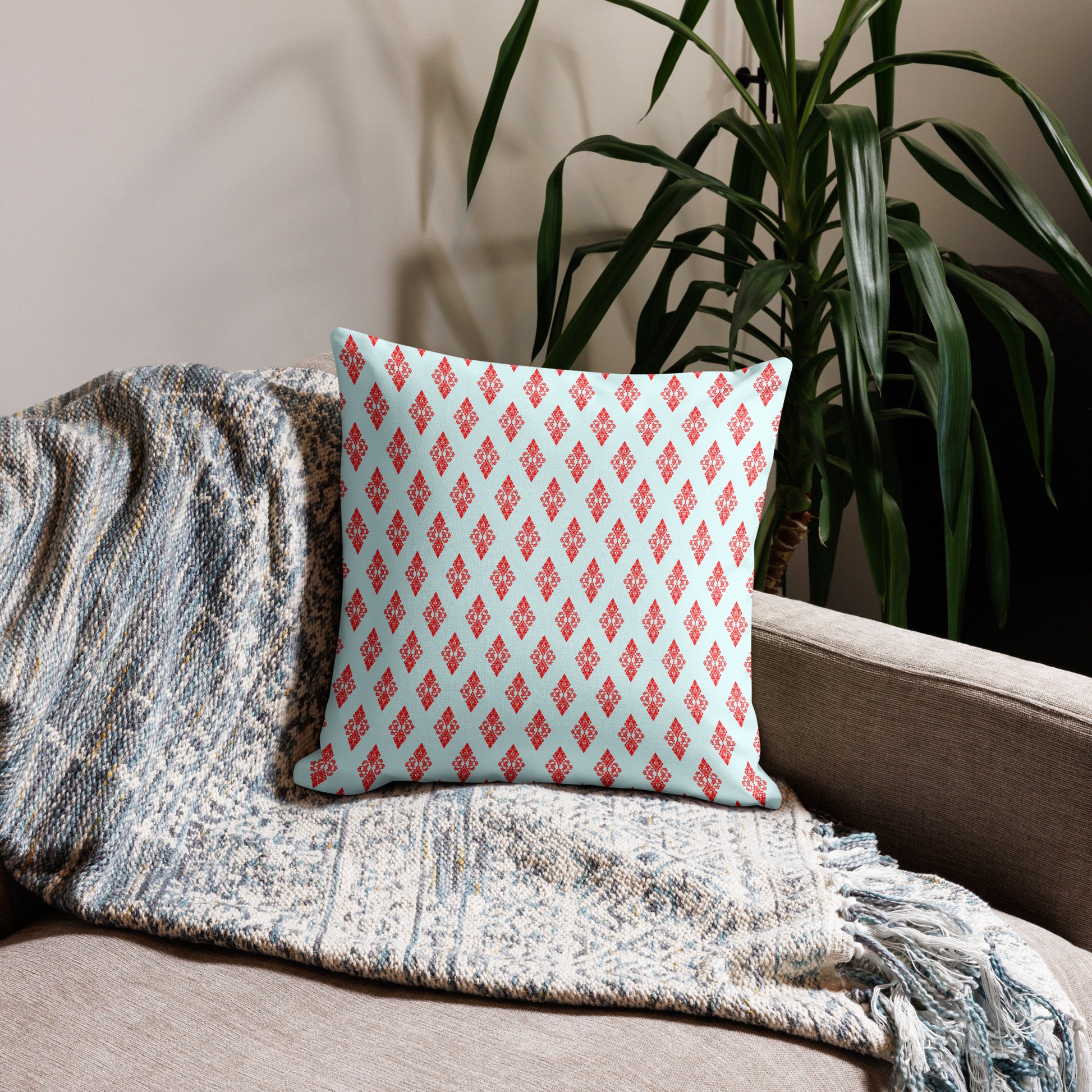 18″×18″ premium throw pillow with the 'Digon' sky blue and red geometric pattern on a couch.