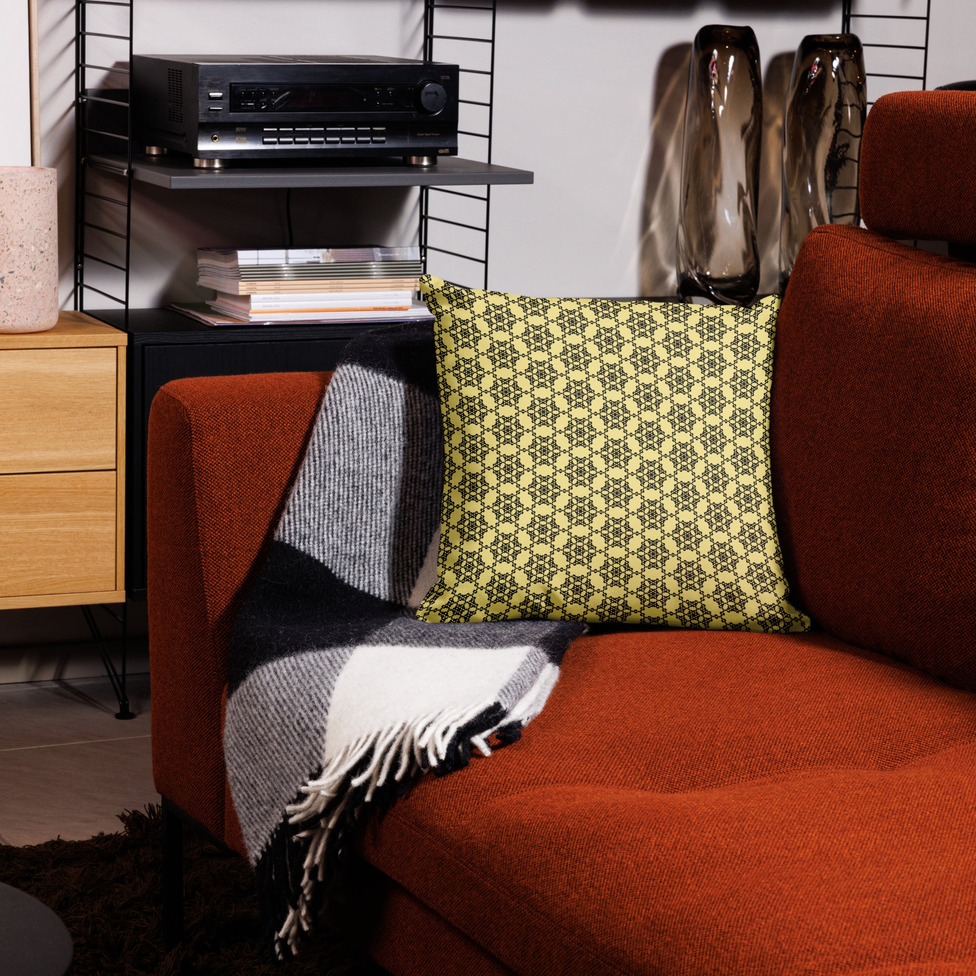 18″×18″ premium throw pillow with the 'Hexagon' yellow and black geometric pattern on a couch.