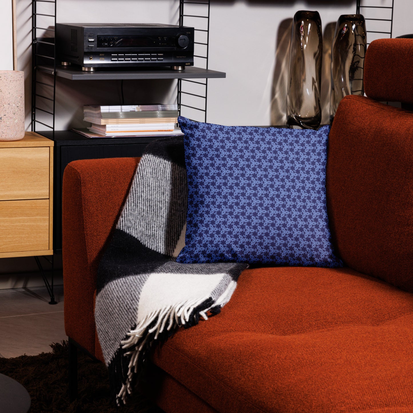18″×18″ premium throw pillow with the 'Trigon' navy and blue geometric pattern on a couch.