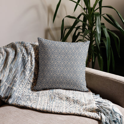 18″×18″ premium throw pillow with the ‘Octagon’ navy and beige geometric pattern on a sofa with fringed blanket.