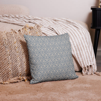 18″×18″ premium throw pillow with the ‘Octagon’ navy and beige geometric pattern on a bed with striped blanket.