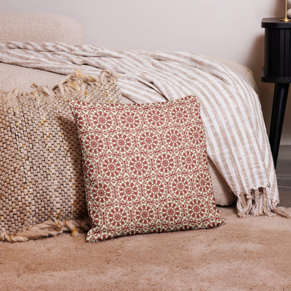 18″×18″ premium throw pillow with the ‘Decagon’ terracotta and beige geometric pattern on a bedroom floor with striped linen throws.