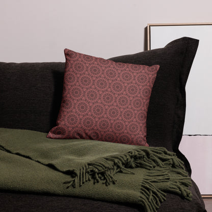 18″×18″ premium throw pillow with the 'Dodecagon' rose geometric pattern on dark sofa with green fringed throw.
