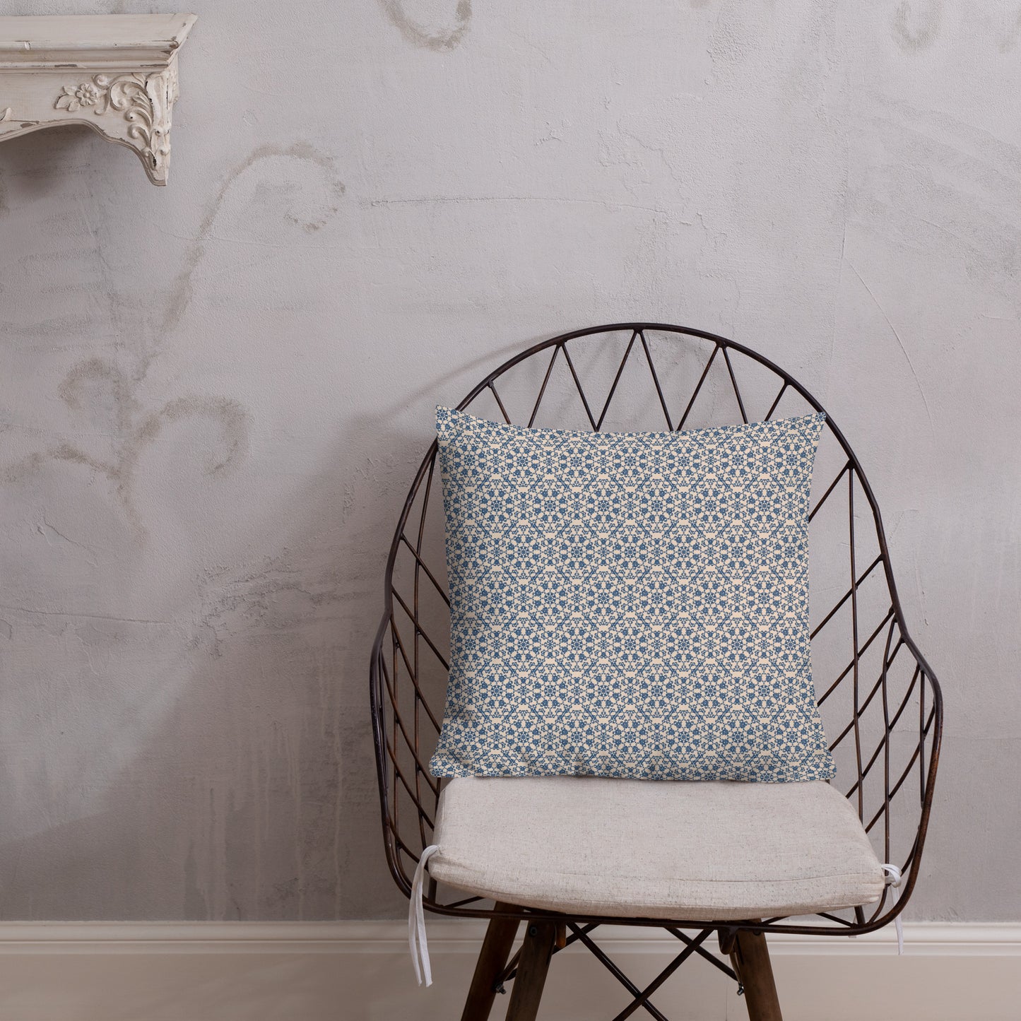 18″×18″ premium throw pillow with the ‘Octagon’ navy and beige geometric pattern on a wire chair.
