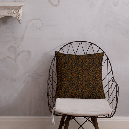 18″×18″ premium throw pillow with the 'Enneagon' black & gold geometric pattern on a wire chair.