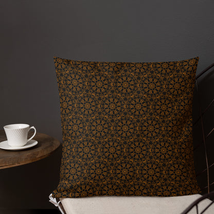 18″×18″ premium throw pillow with the 'Enneagon' black & gold geometric pattern on a chair with coffee cup on side table.
