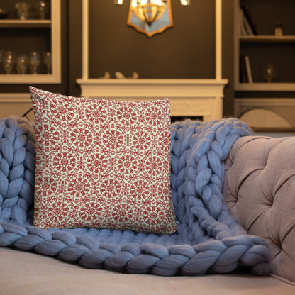 18″×18″ premium throw pillow with the ‘Decagon’ terracotta and beige geometric pattern on a blue sofa with a chunky knit blanket.
