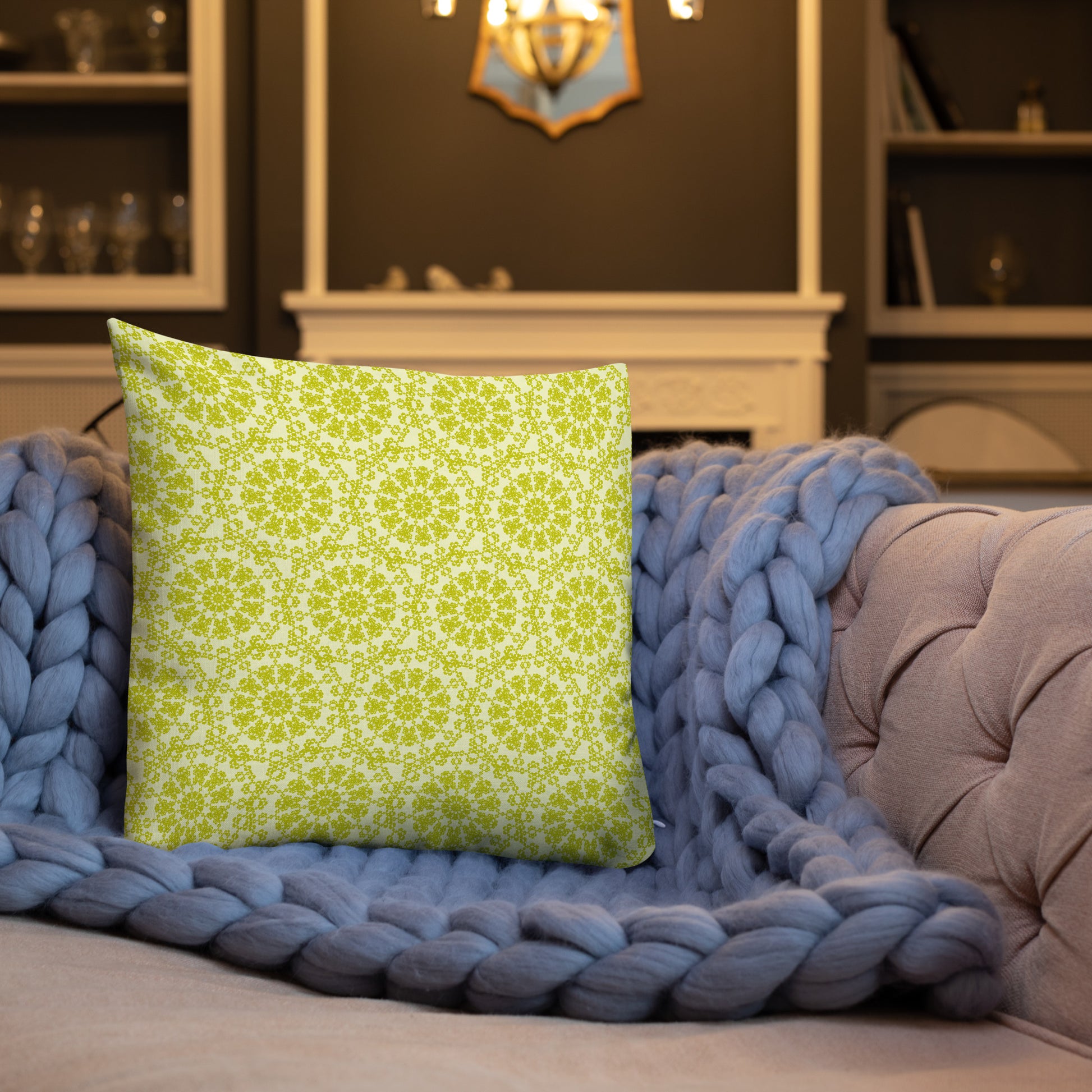 18″×18″ premium throw pillow with the 'Hendecagon' yellow-green geometric pattern on a sofa with chunky knit blanket