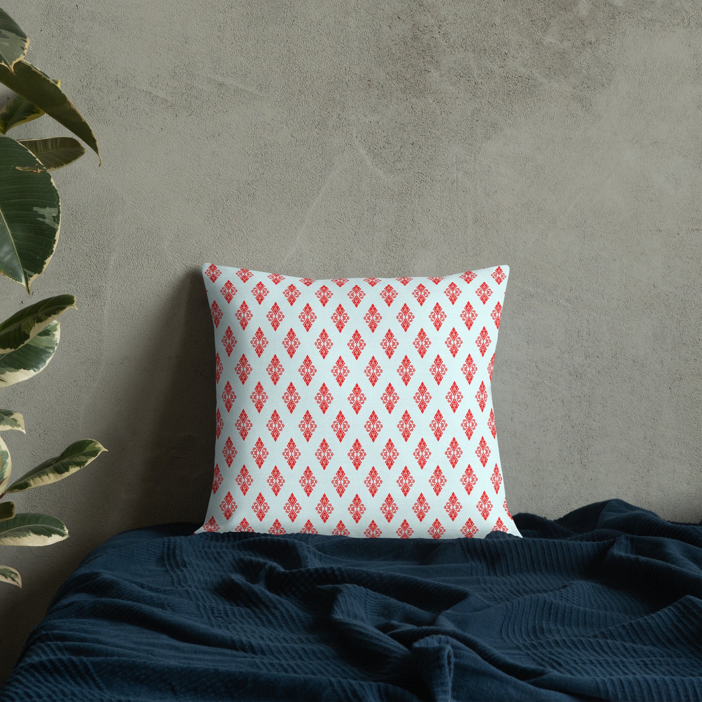 18″×18″ premium throw pillow with the 'Digon' sky blue and red geometric pattern on a bed.