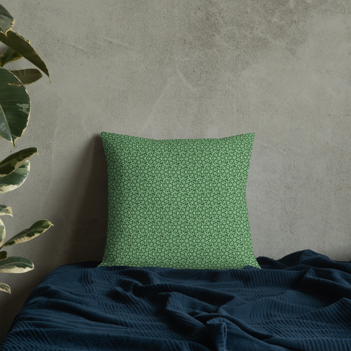 18″×18″ premium throw pillow with the 'Heptagon' green geometric pattern on a bed.