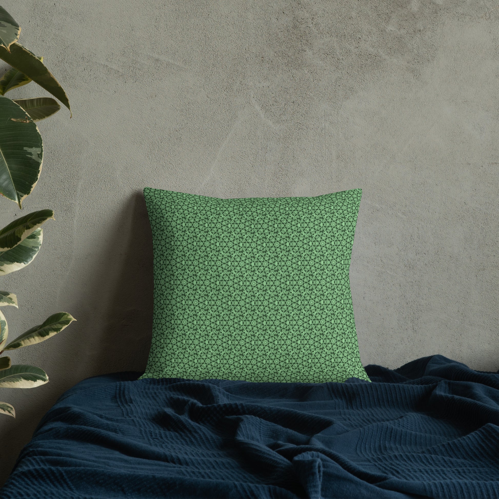 18″×18″ premium throw pillow with the 'Heptagon' green geometric pattern on a bed.