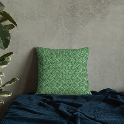 18″×18″ premium throw pillow with the 'Heptagon' green geometric pattern on a bed.