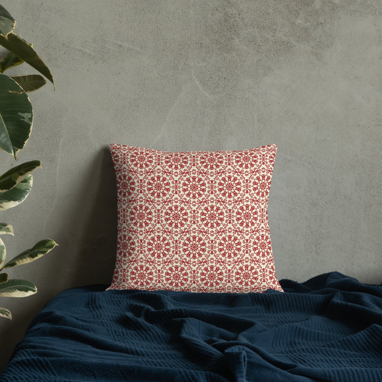 18″×18″ premium throw pillow with the ‘Decagon’ terracotta and beige geometric pattern on a bed with a dark navy blanket.