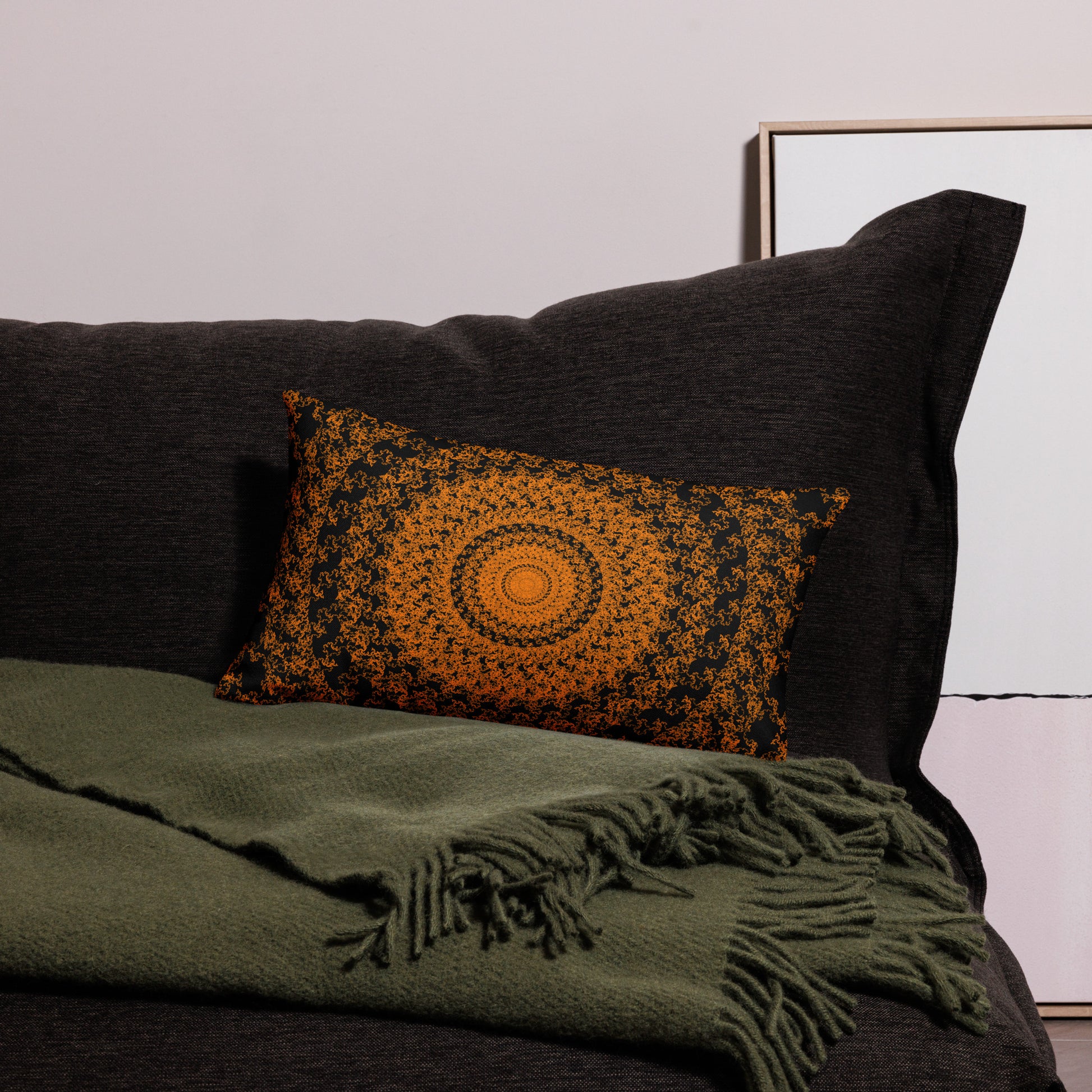 20″×12″ premium throw pillow with the 'The Sun' orange and black geometric design on a couch.
