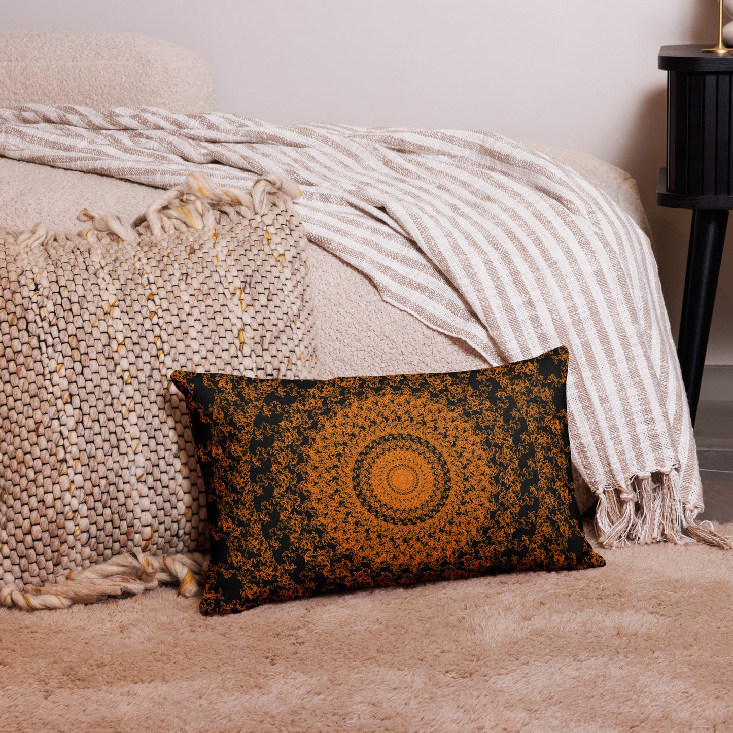 20″×12″ premium throw pillow with the 'The Sun' orange and black geometric design on a couch.