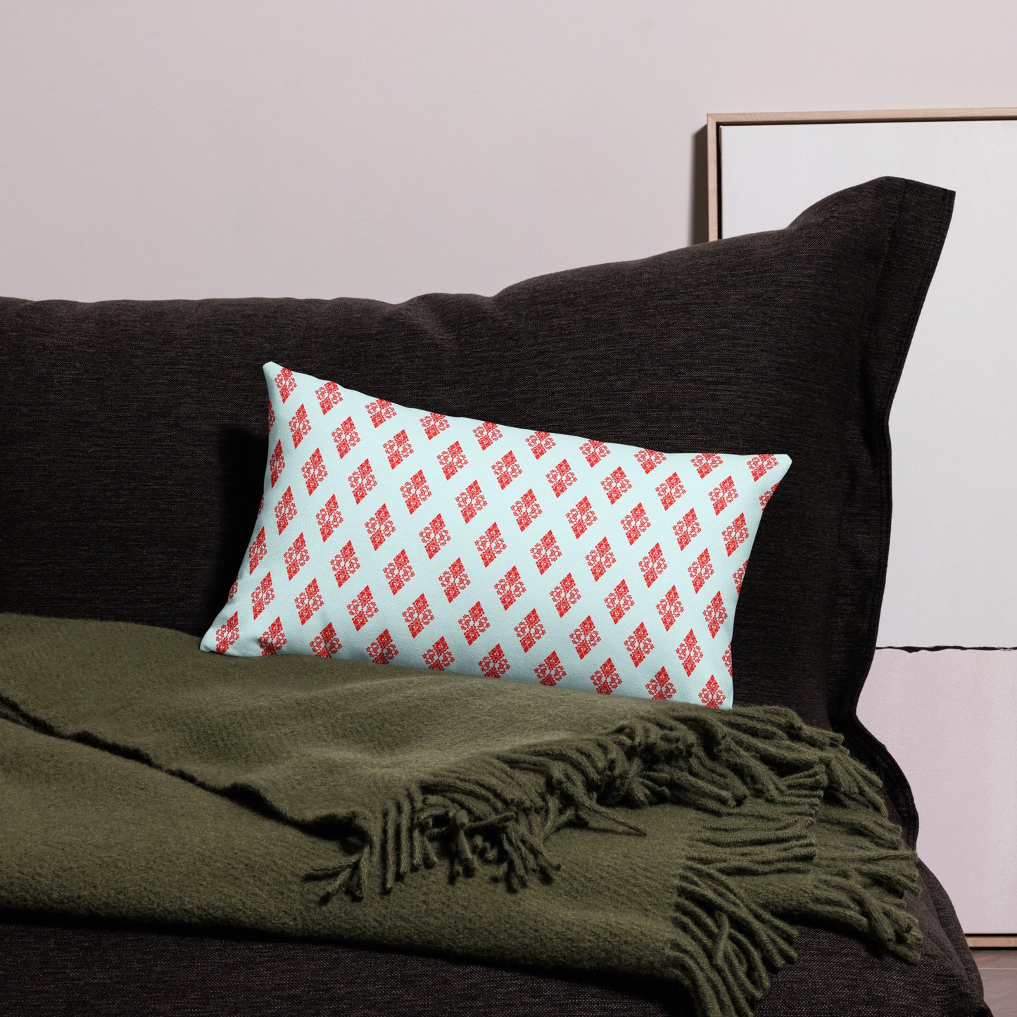 20″×12″ premium throw pillow with the 'Digon' sky blue and red geometric pattern on a couch.