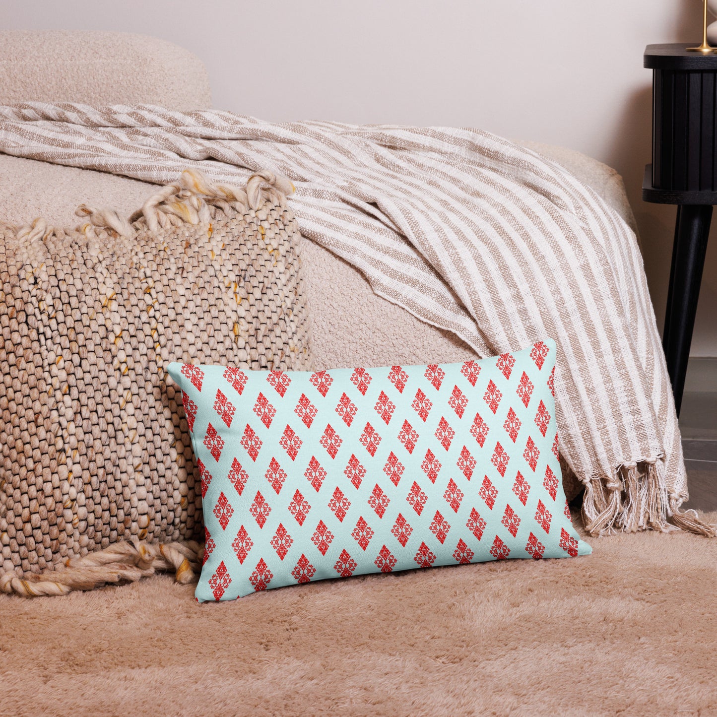 20″×12″ premium throw pillow with the 'Digon' sky blue and red geometric pattern on a couch.