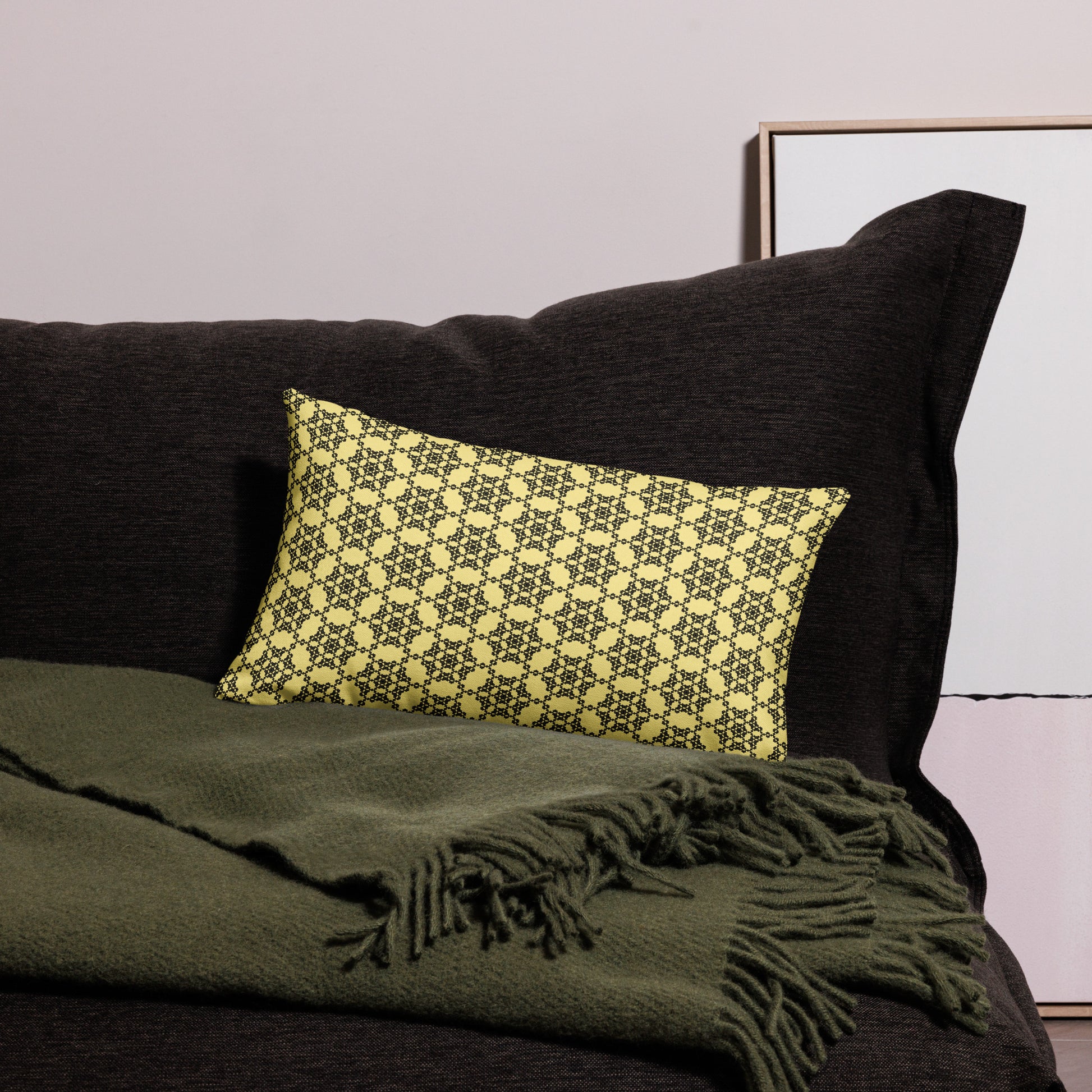 20″×12″ premium throw pillow with the 'Hexagon' yellow and black geometric pattern on a couch.