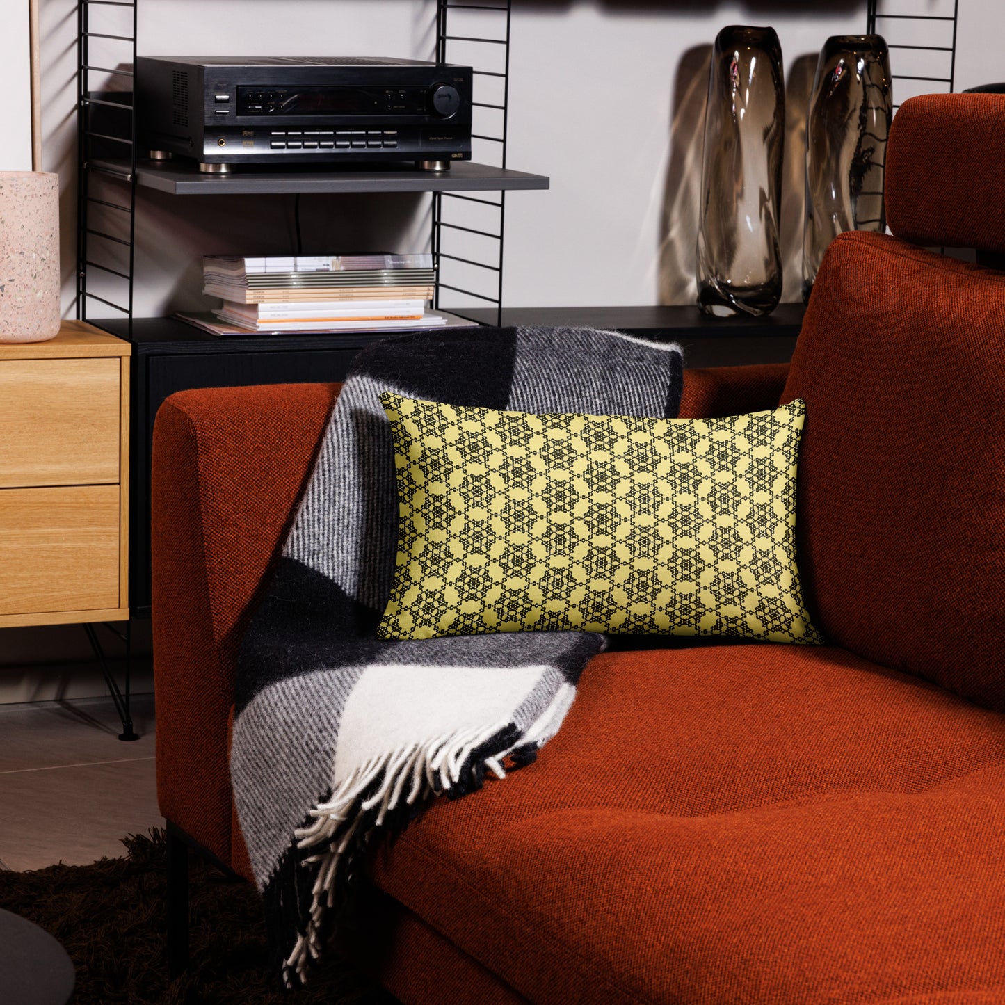 20″×12″ premium throw pillow with the 'Hexagon' yellow and black geometric pattern on a couch.
