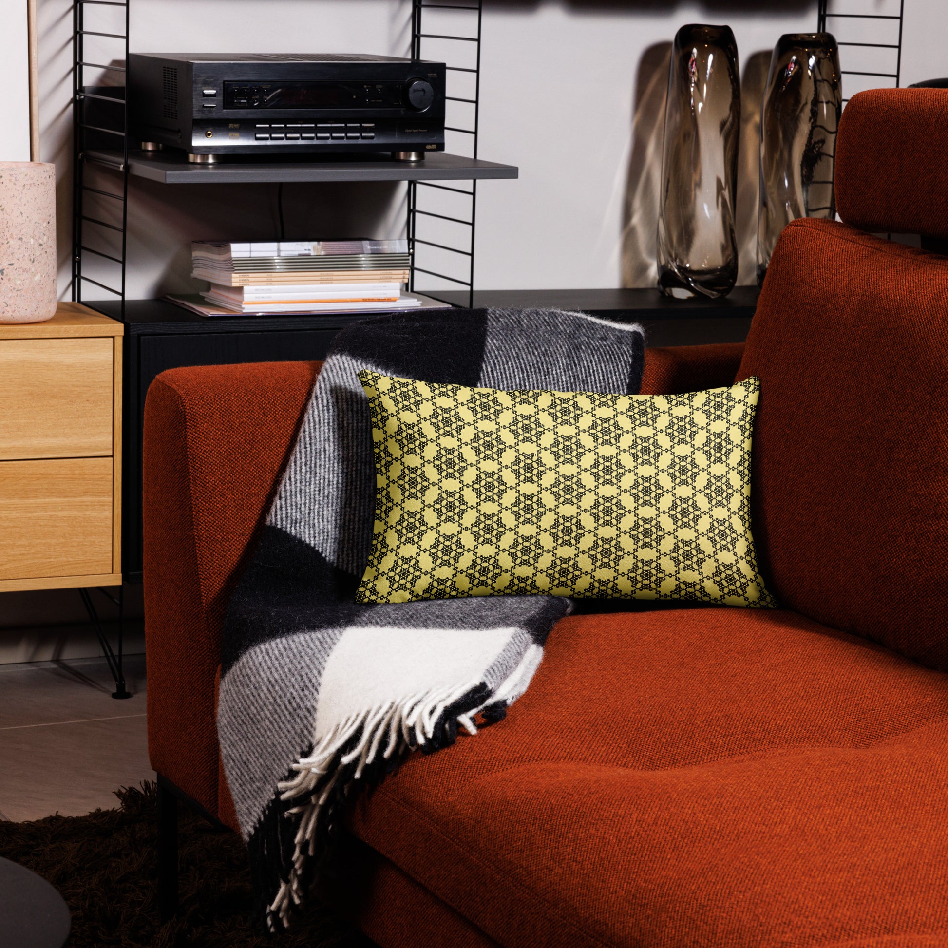 20″×12″ premium throw pillow with the 'Hexagon' yellow and black geometric pattern on a couch.