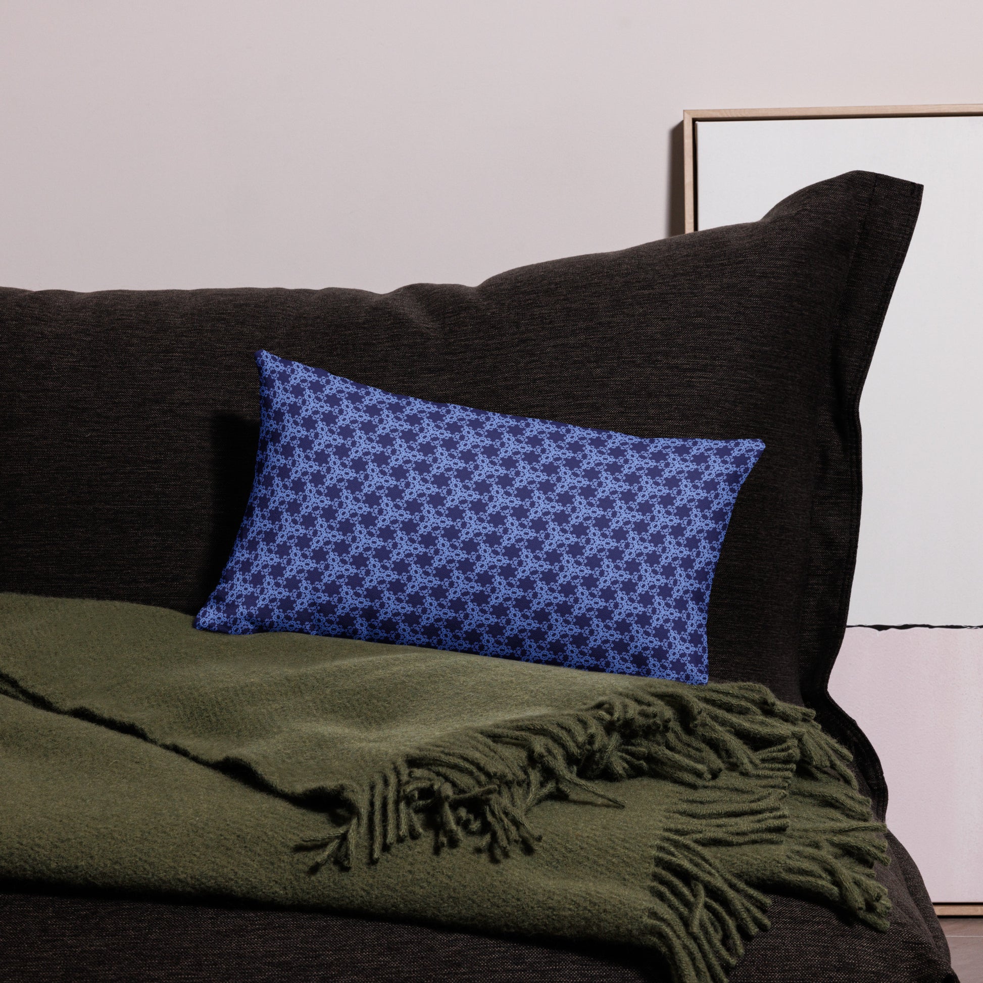 20″×12″ premium throw pillow with the 'Triagon' navy and blue geometric pattern on a couch.