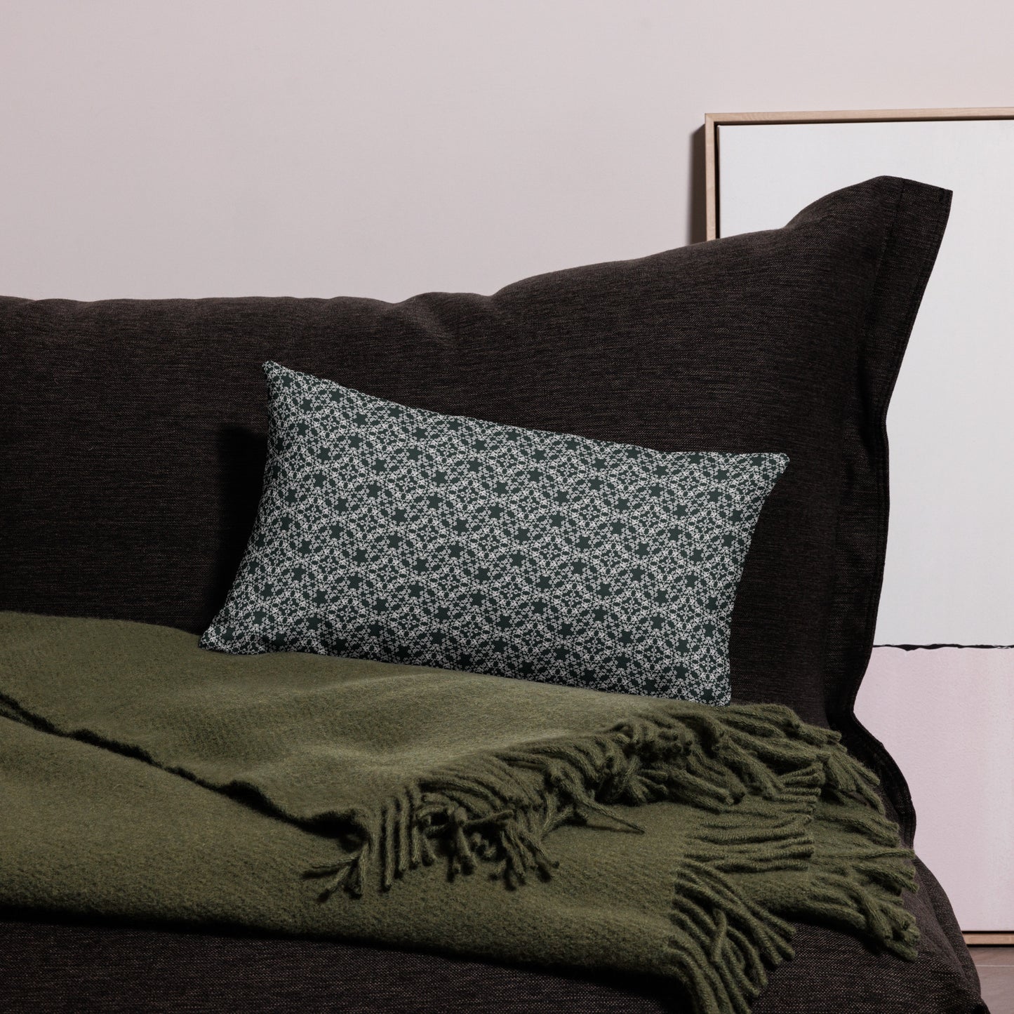 20″×12″ premium throw pillow with the 'Tetragon' charcoal and white geometric pattern on a couch.