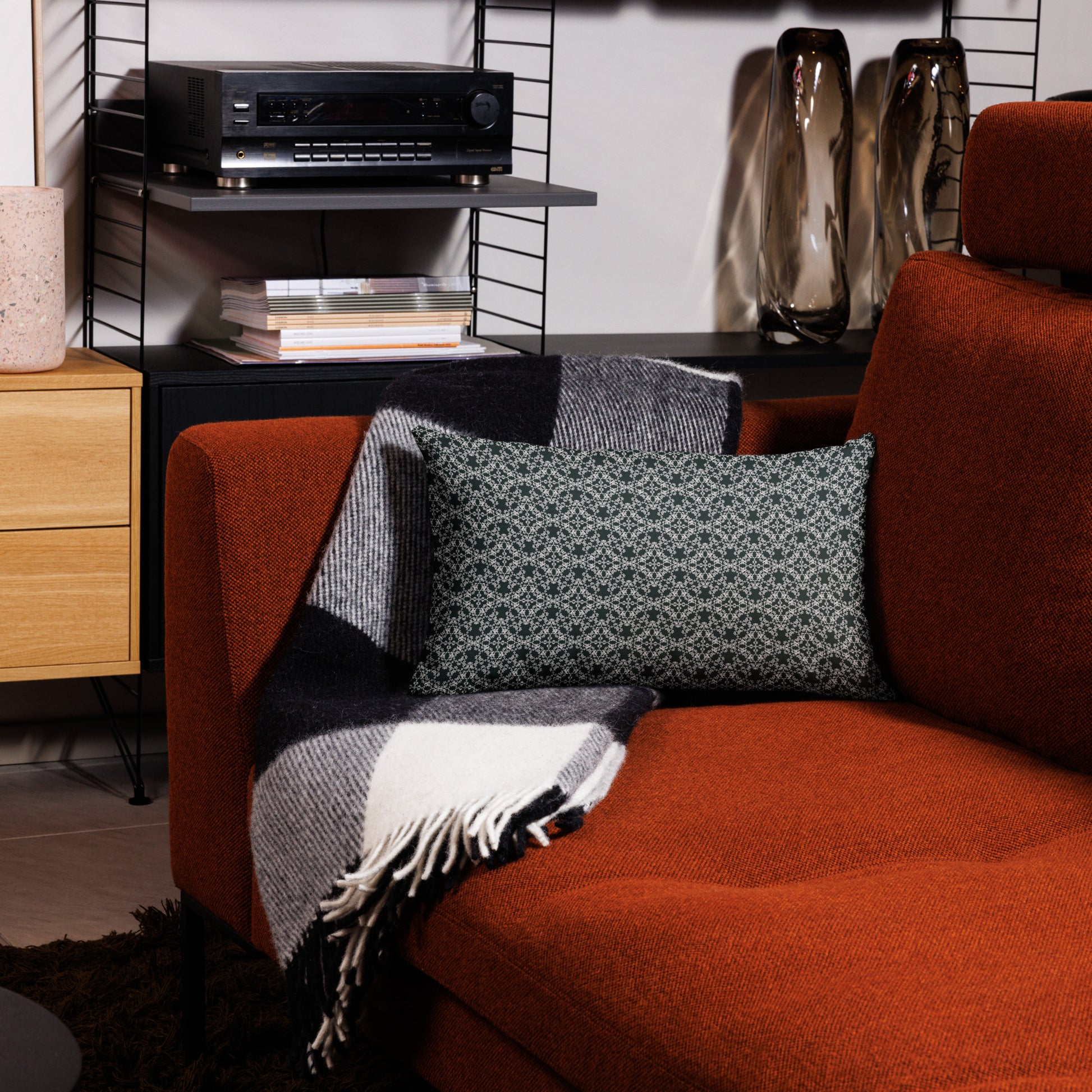 20″×12″ premium throw pillow with the 'Tetragon' charcoal and white geometric pattern on a couch.