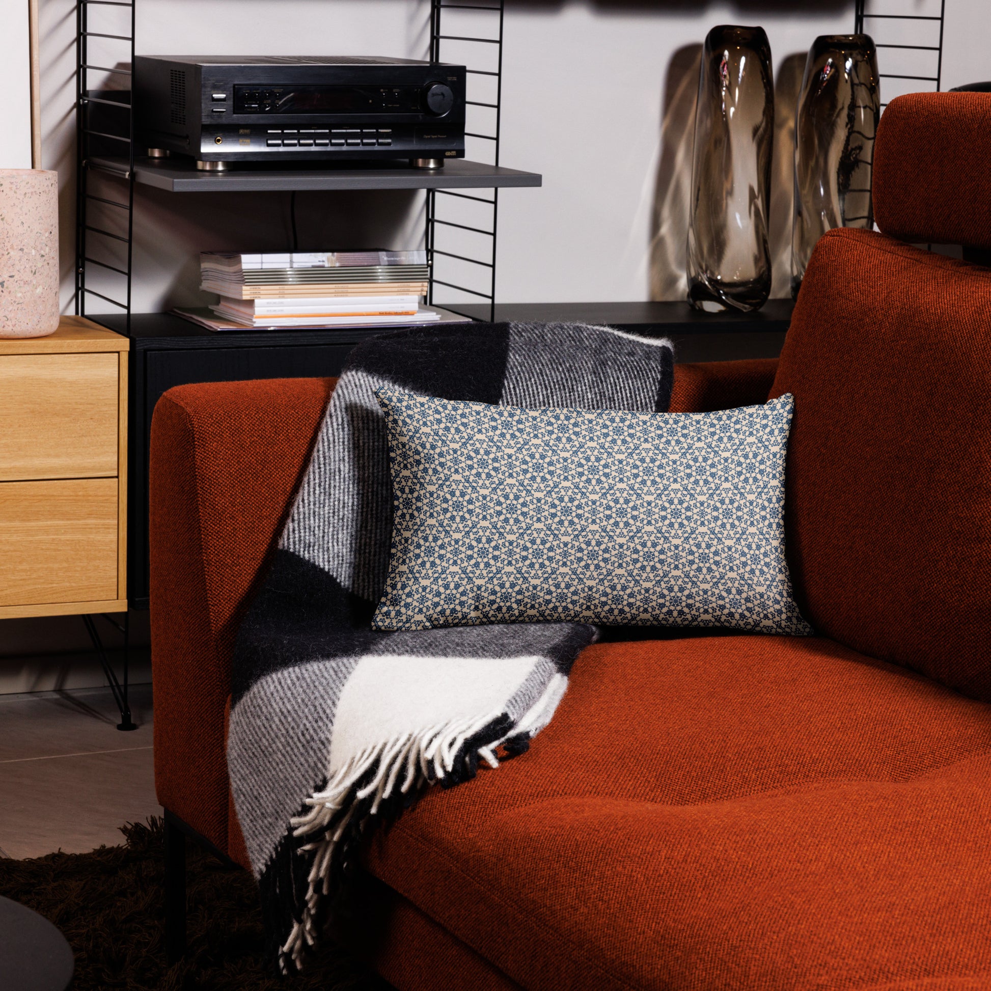 20″×12″ premium throw pillow with the ‘Octagon’ navy and beige geometric pattern on an armchair.
