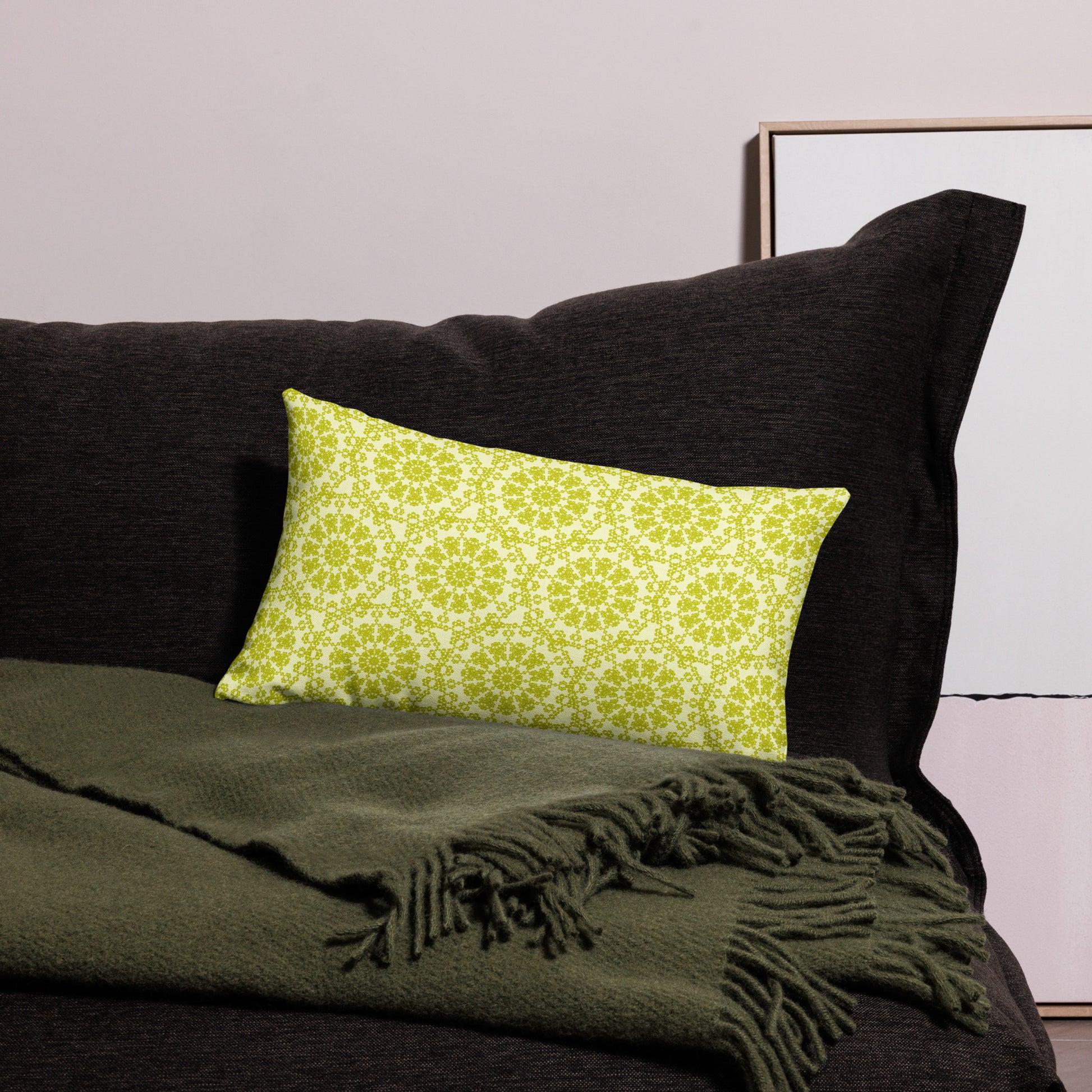 20″×12″ premium throw pillow with the 'Hendecagon' yellow-green geometric pattern on a dark sofa with green throw
