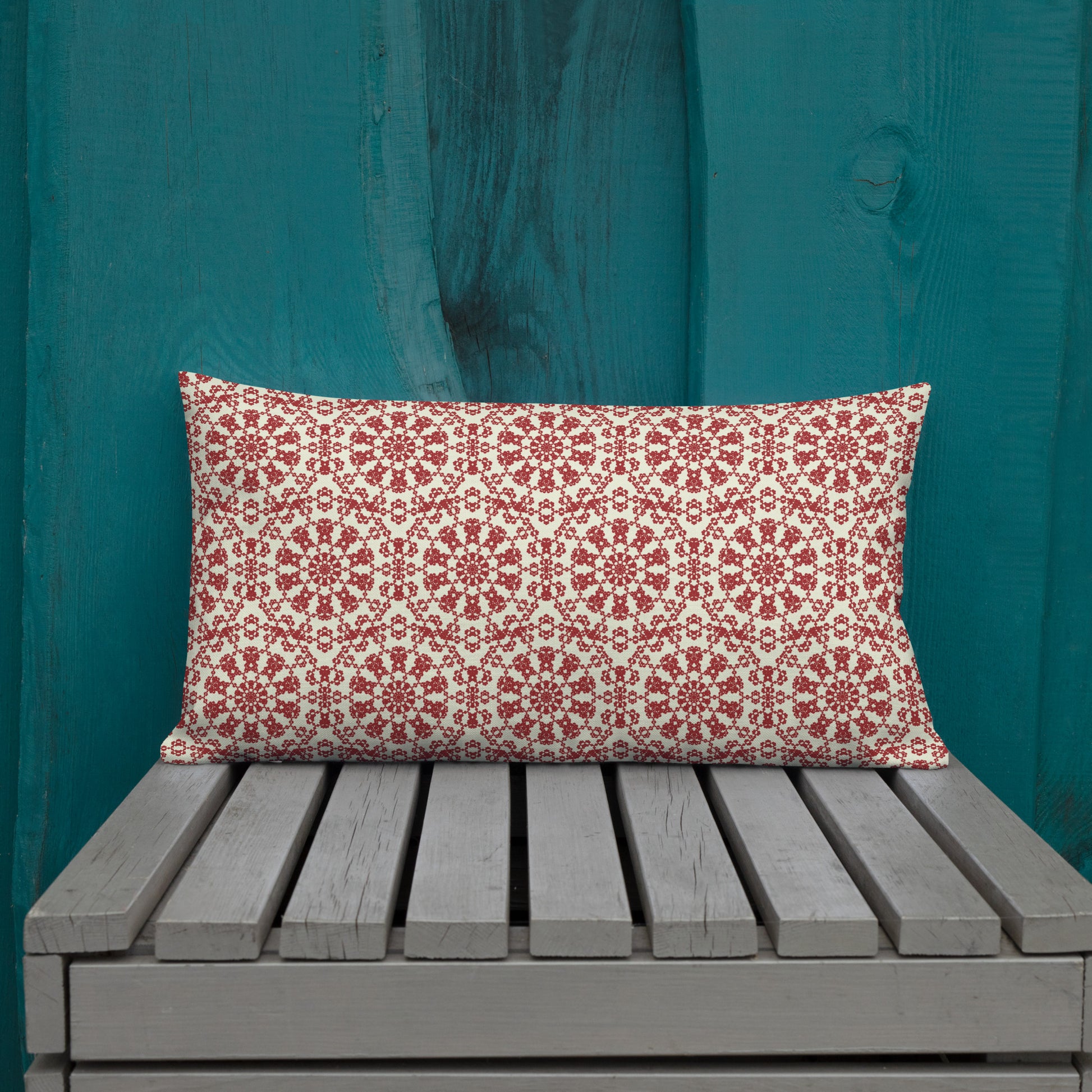 20″×12″ premium throw pillow with the ‘Decagon’ terracotta and beige geometric pattern on an outdoor bench with a teal wooden backdrop.