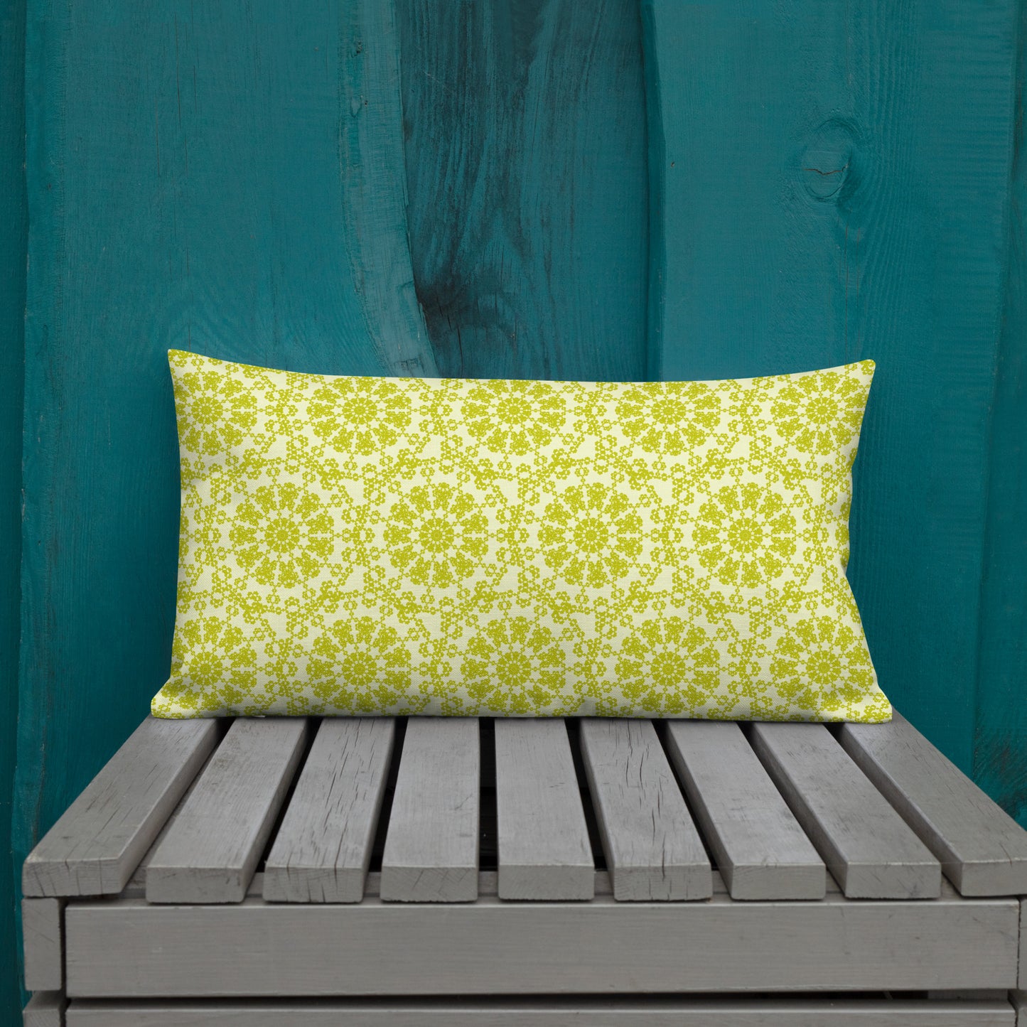 20″×12″ premium throw pillow with the 'Hendecagon' yellow-green geometric pattern on a wooden bench with teal wall