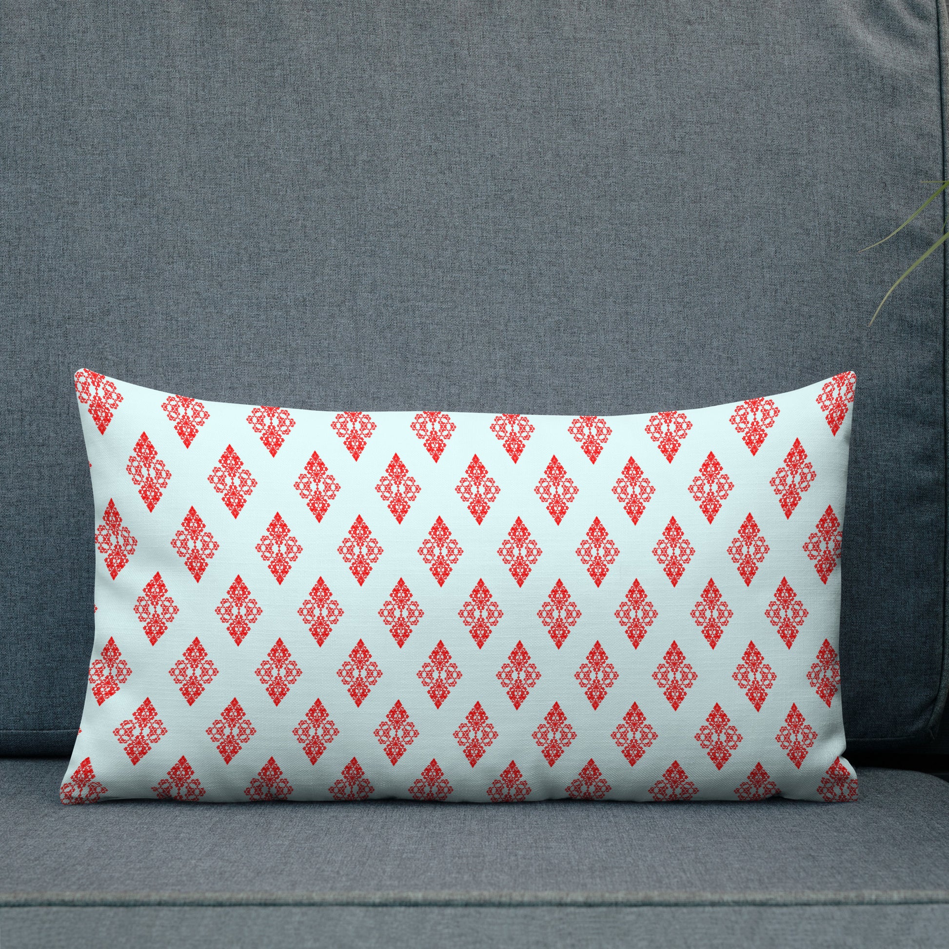 20″×12″ premium throw pillow with the 'Digon' sky blue and red geometric pattern shown in a lifestyle setting.