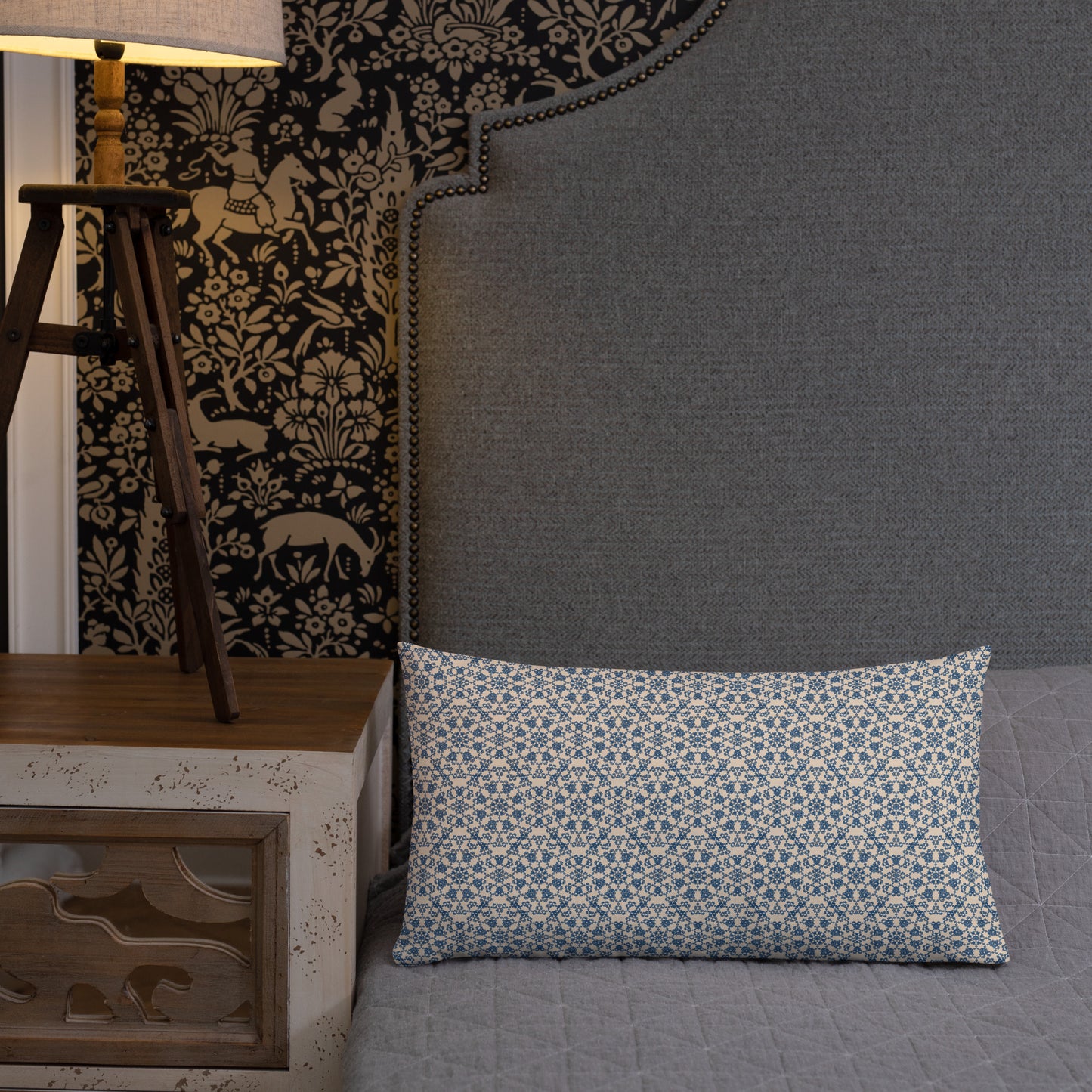 20″×12″ premium throw pillow with the ‘Octagon’ navy and beige geometric pattern on a bed with upholstered headboard.