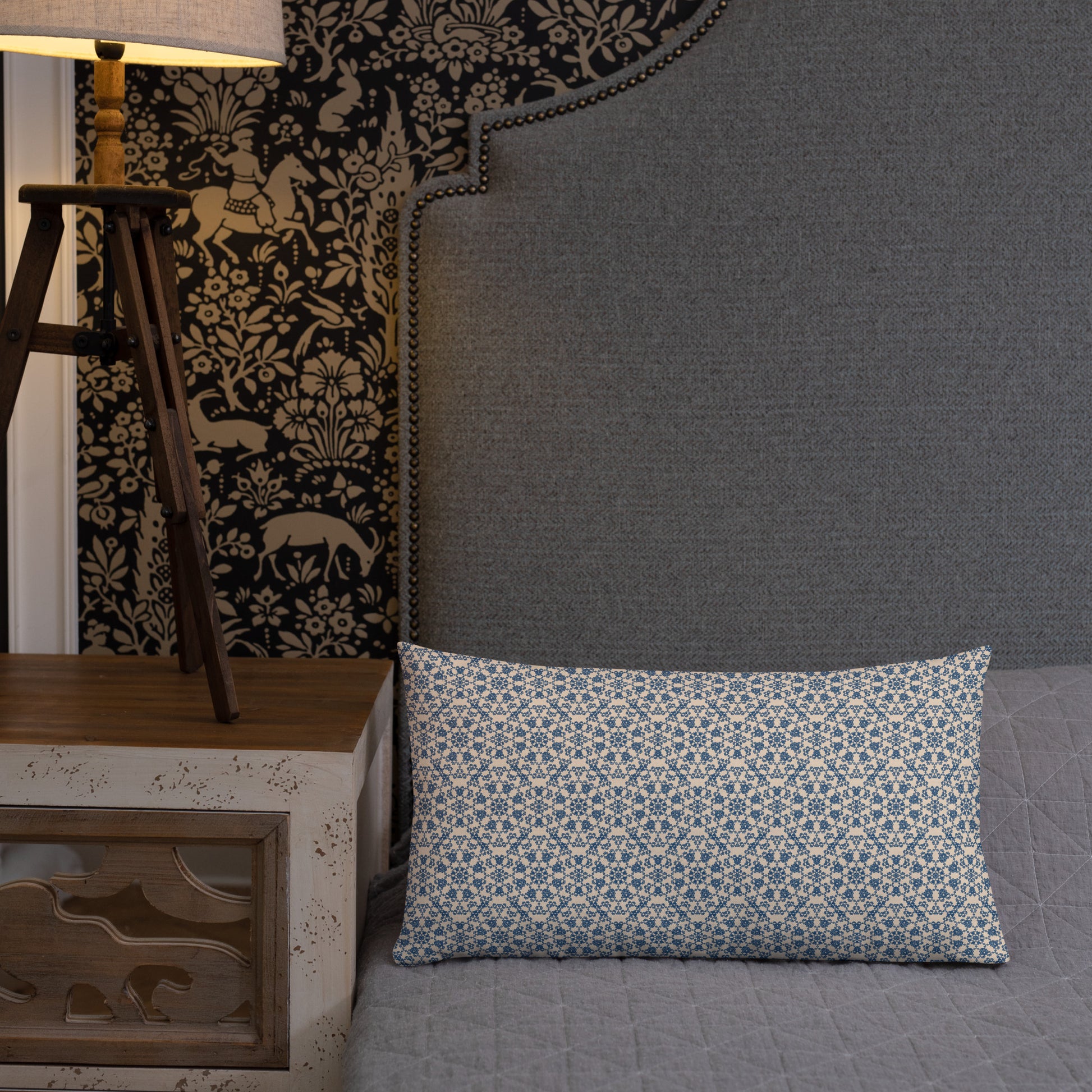 20″×12″ premium throw pillow with the ‘Octagon’ navy and beige geometric pattern on a bed with upholstered headboard.