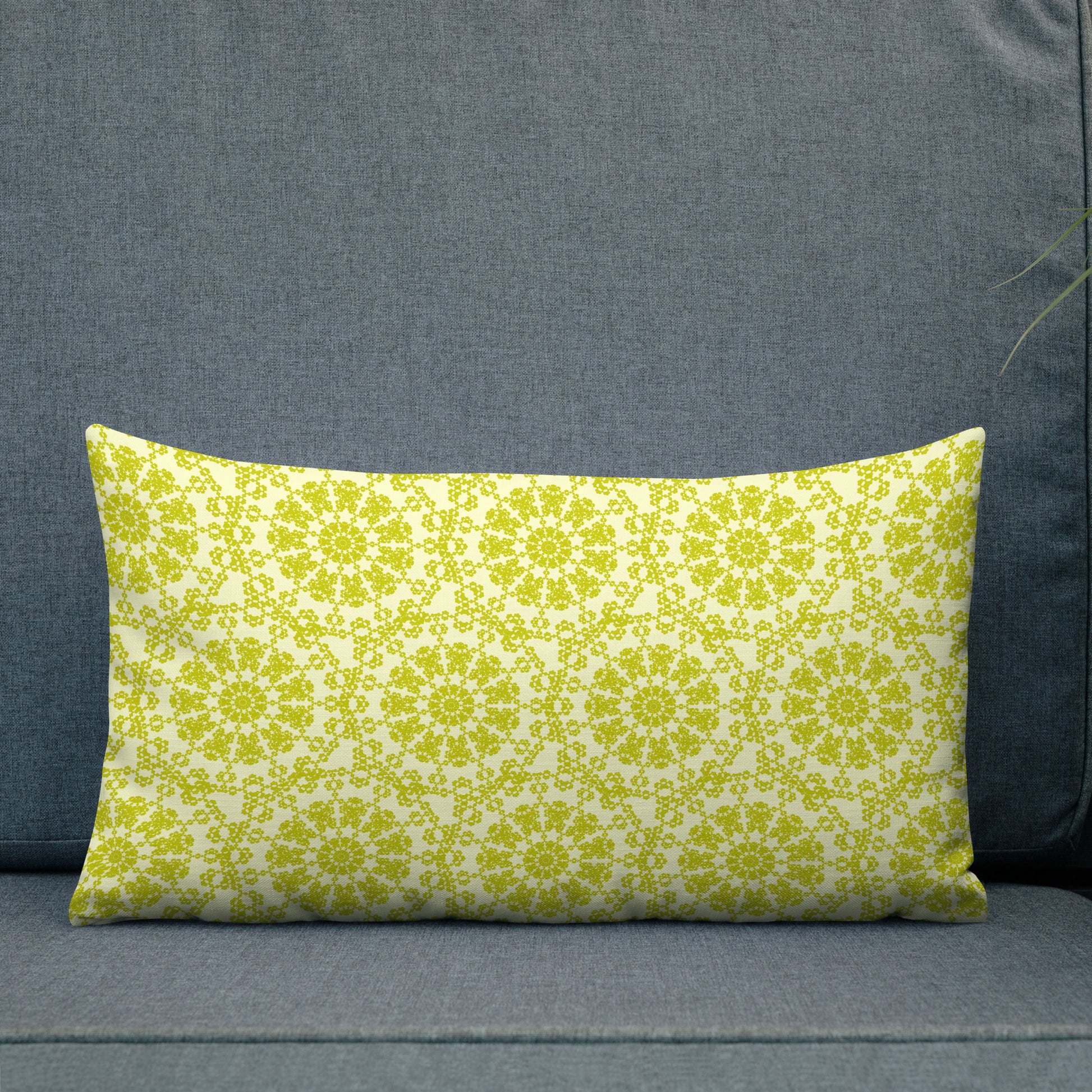 20″×12″ premium throw pillow with the 'Hendecagon' yellow-green geometric pattern on an outdoor sofa with teal planter