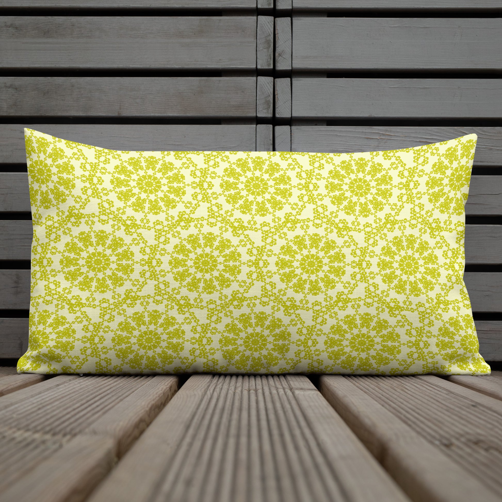 20″×12″ premium throw pillow with the 'Hendecagon' yellow-green geometric pattern on an outdoor wooden deck