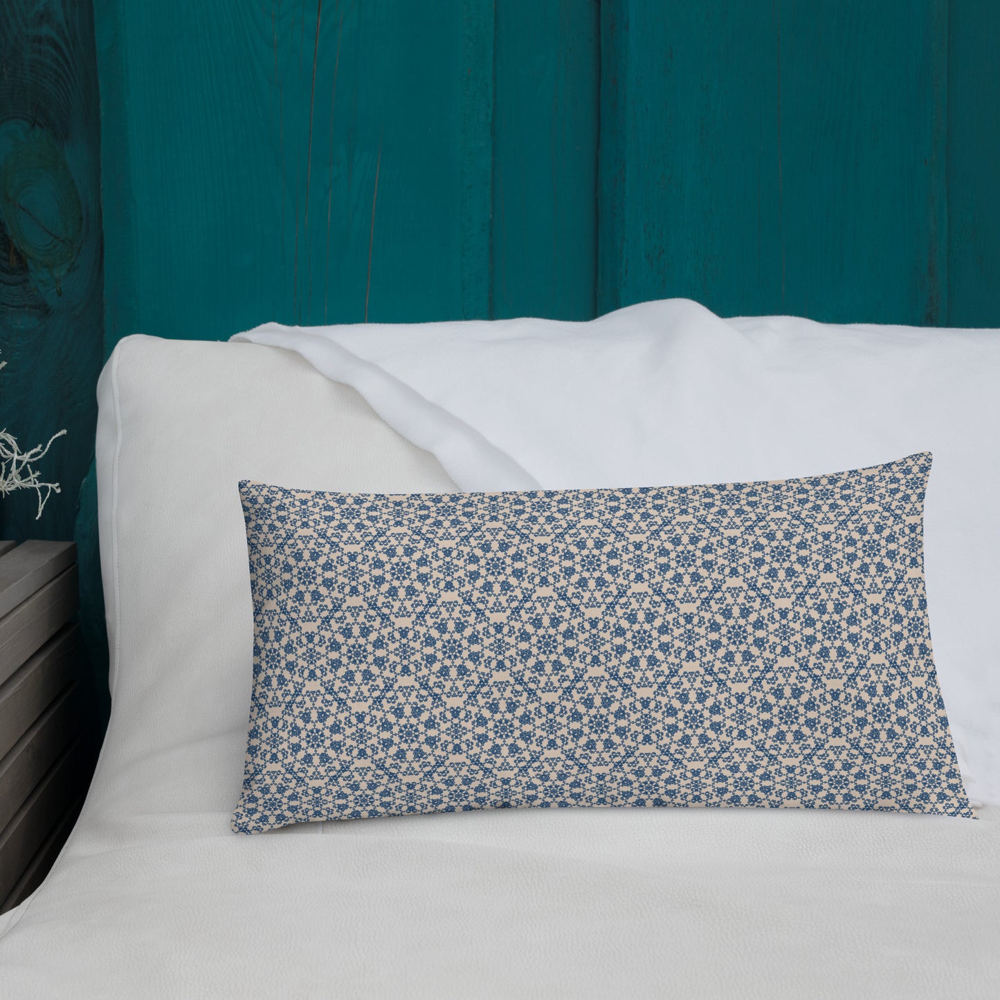 20″×12″ premium throw pillow with the ‘Octagon’ navy and beige geometric pattern on a white sofa with teal wooden wall.