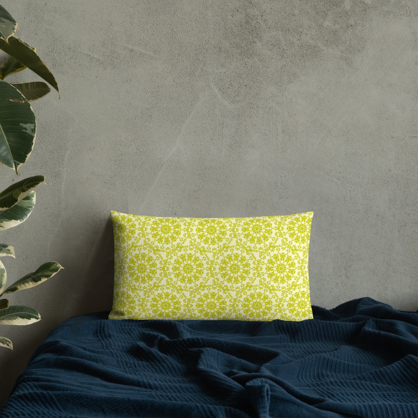20″×12″ premium throw pillow with the 'Hendecagon' yellow-green geometric pattern on a bed with concrete wall