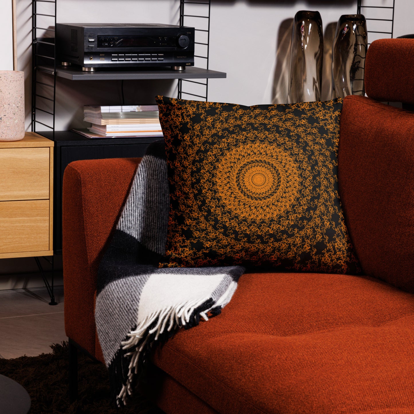 22″×22″ premium throw pillow with the 'The Sun' orange and black geometric design on a couch.